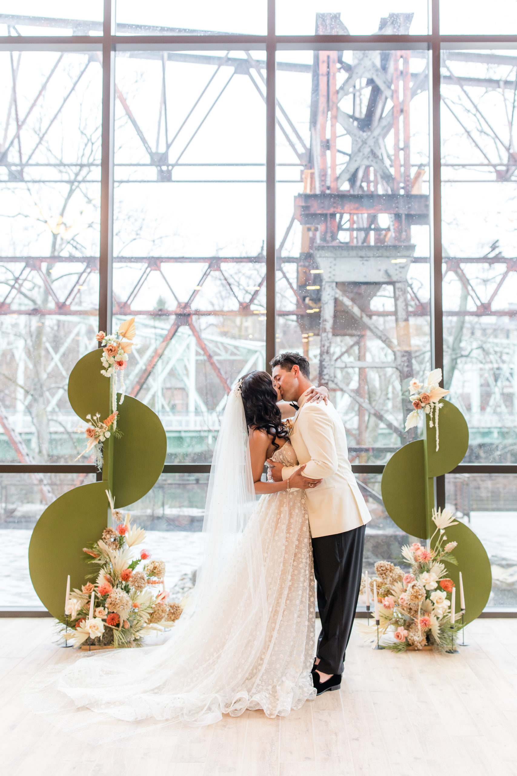 couple kisses by window at Philadelphia wedding editorial at Ironworks at Pencoyd Landing