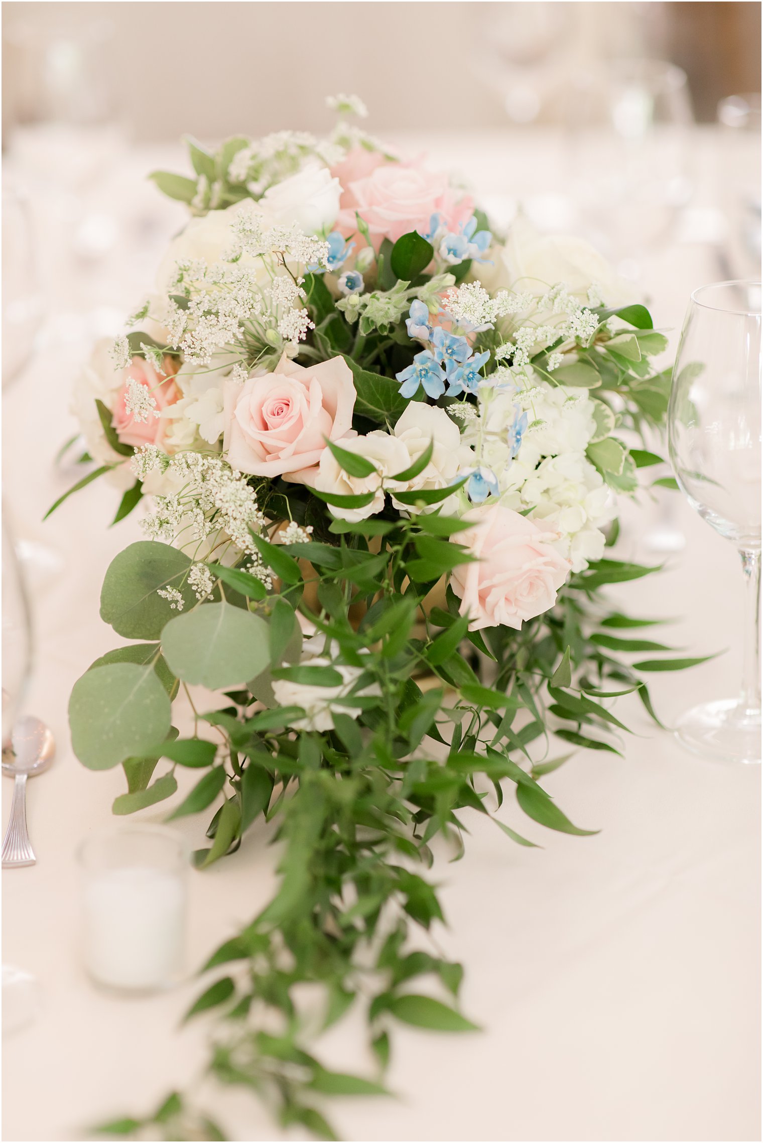 wedding floral arrangement for reception with pops of blue