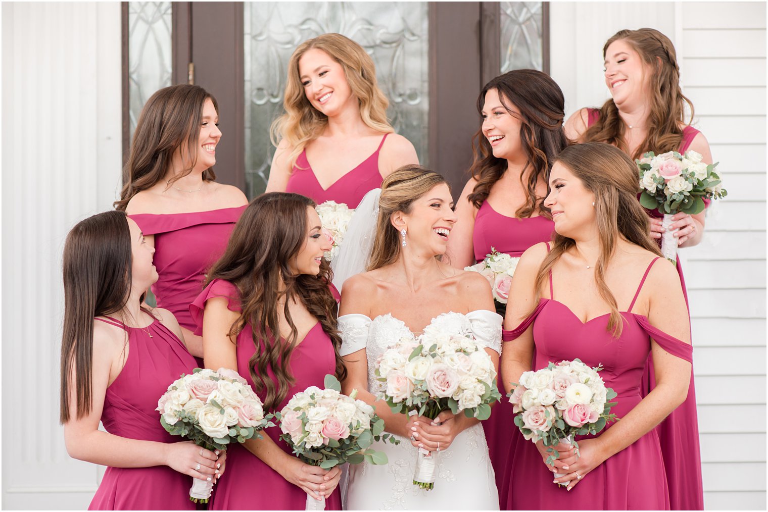 bride laughs with bridesmaids in magenta gowns before spring wedding