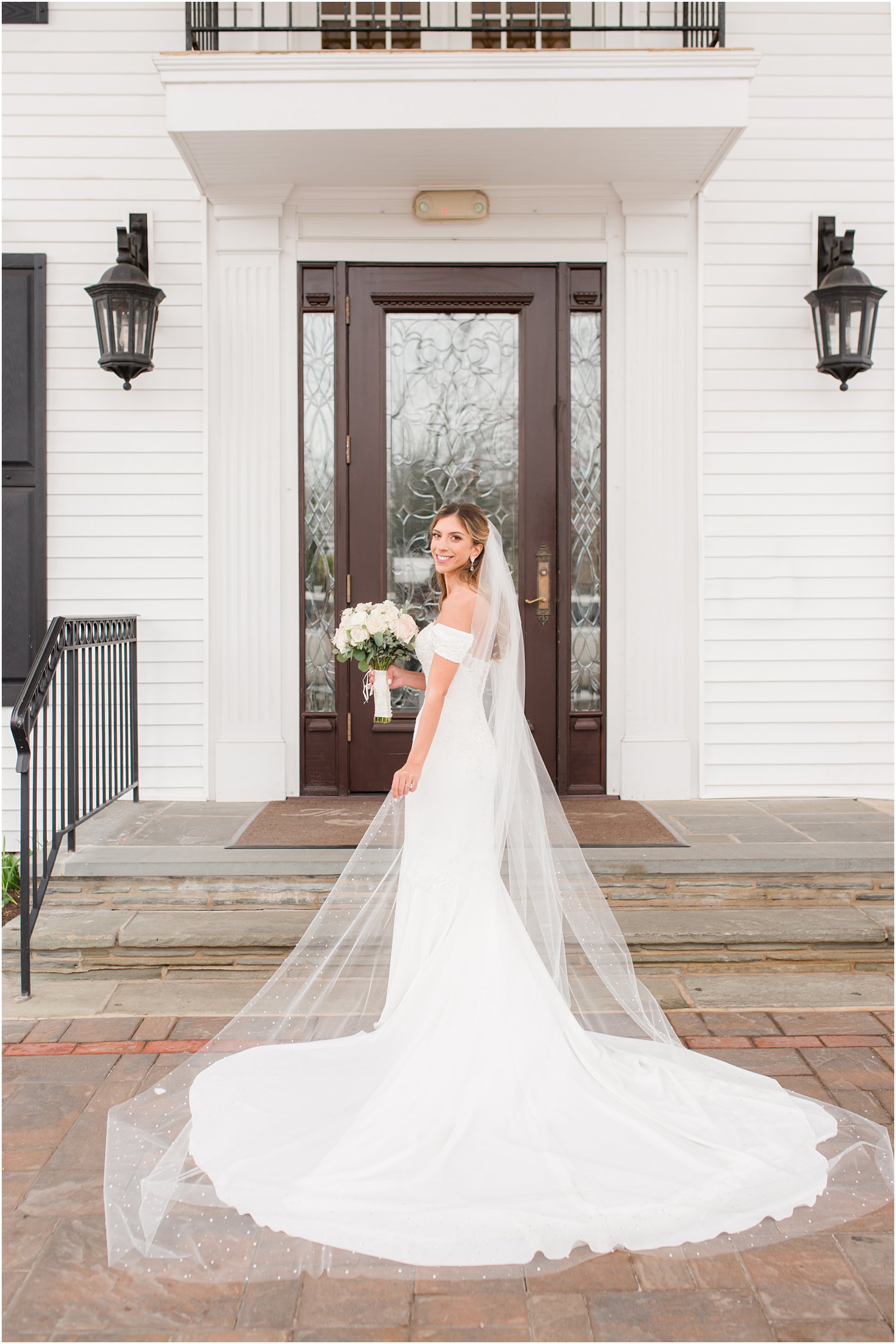 bride poses with train and veil behind her before spring Park Savoy Estate wedding
