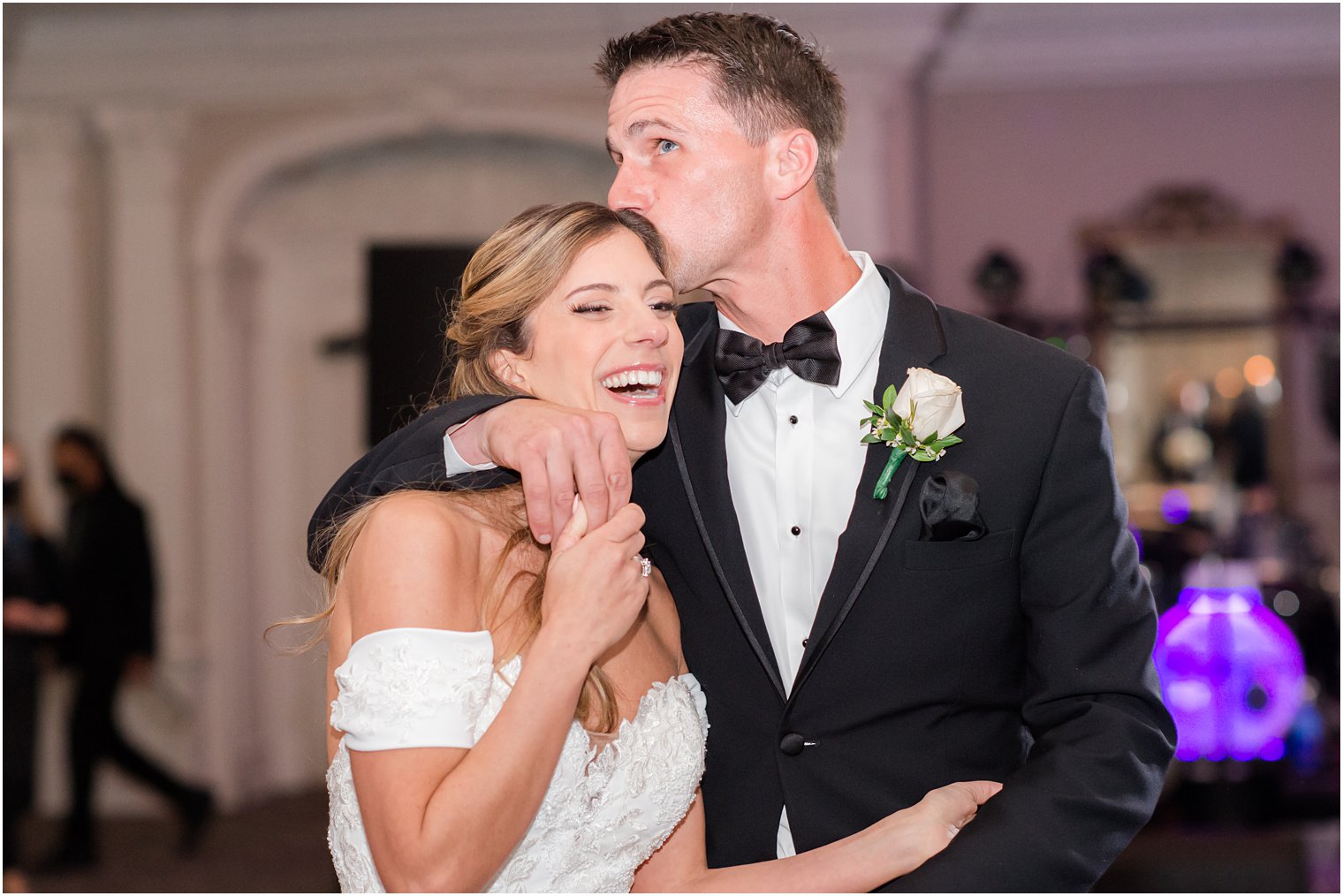 groom kisses bride's forehead during NJ wedding reception 