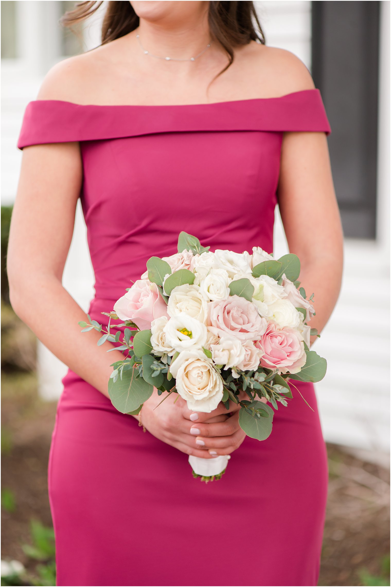 bridesmaid holds bouquet of ivory and pink flowers before spring Park Savoy Estate wedding