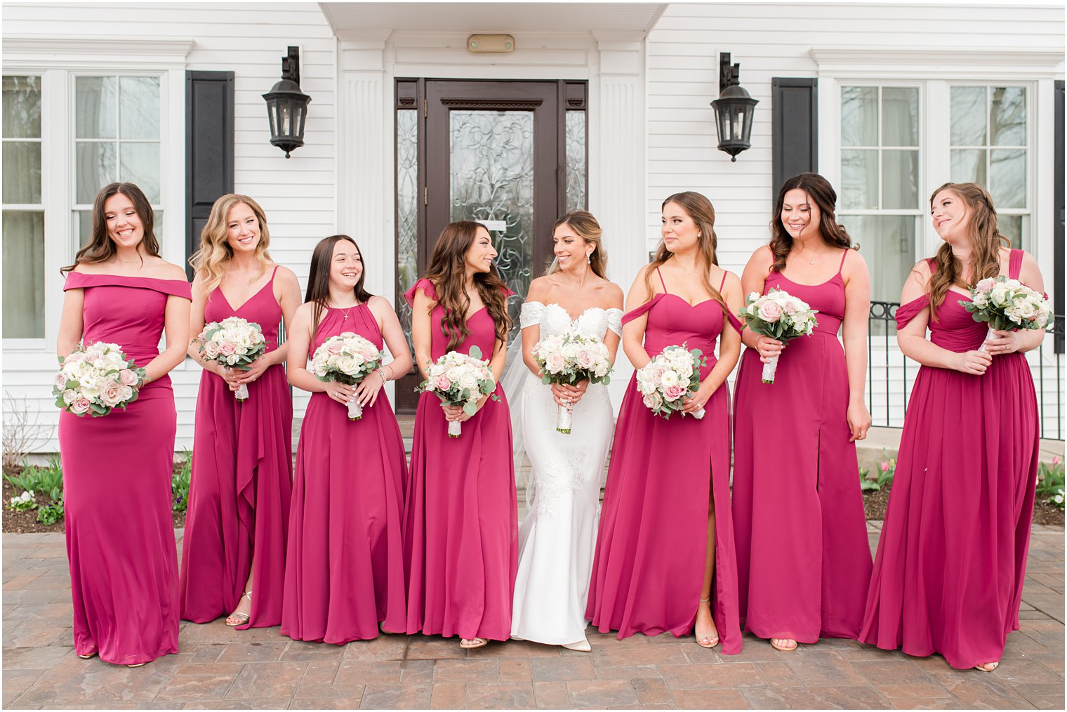 bride walks with bridesmaids in cranberry gowns before spring wedding 