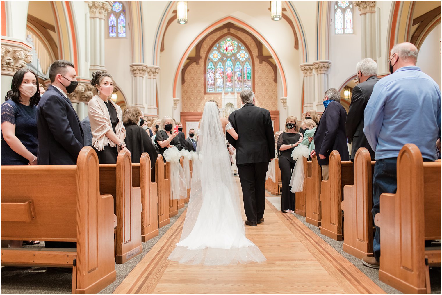 bride walks down aisle during traditional Catholic Church wedding in New Jersey