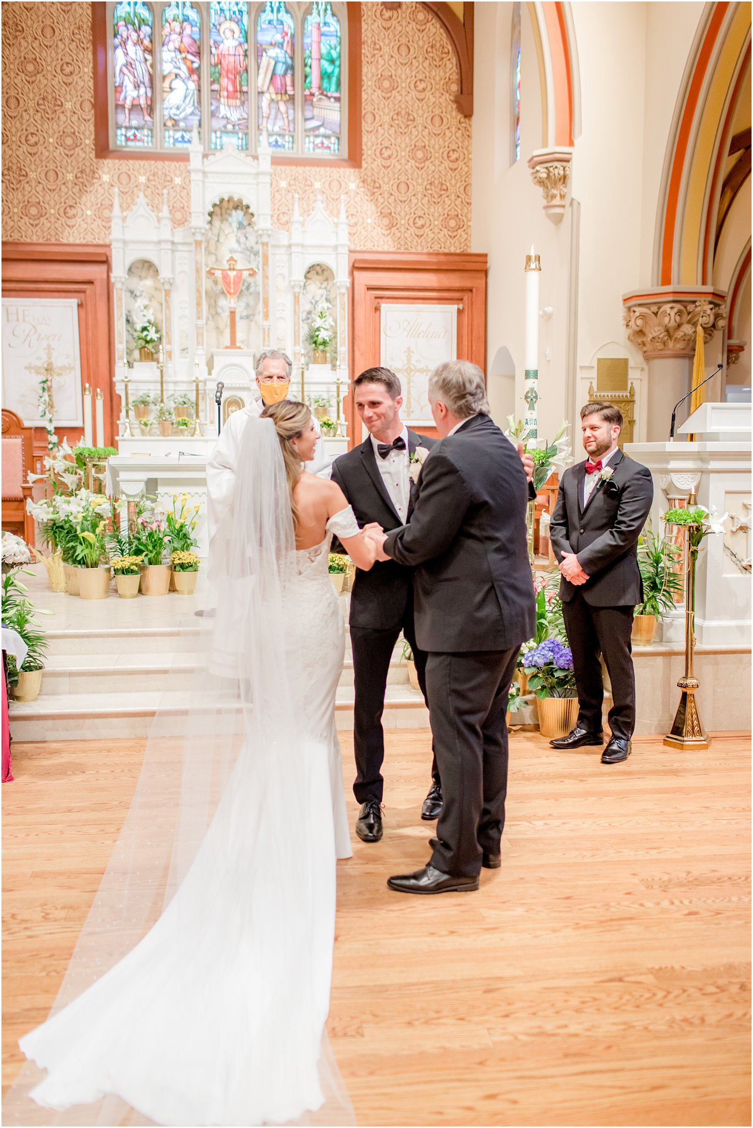 father gives bride away during traditional Catholic Church wedding in New Jersey