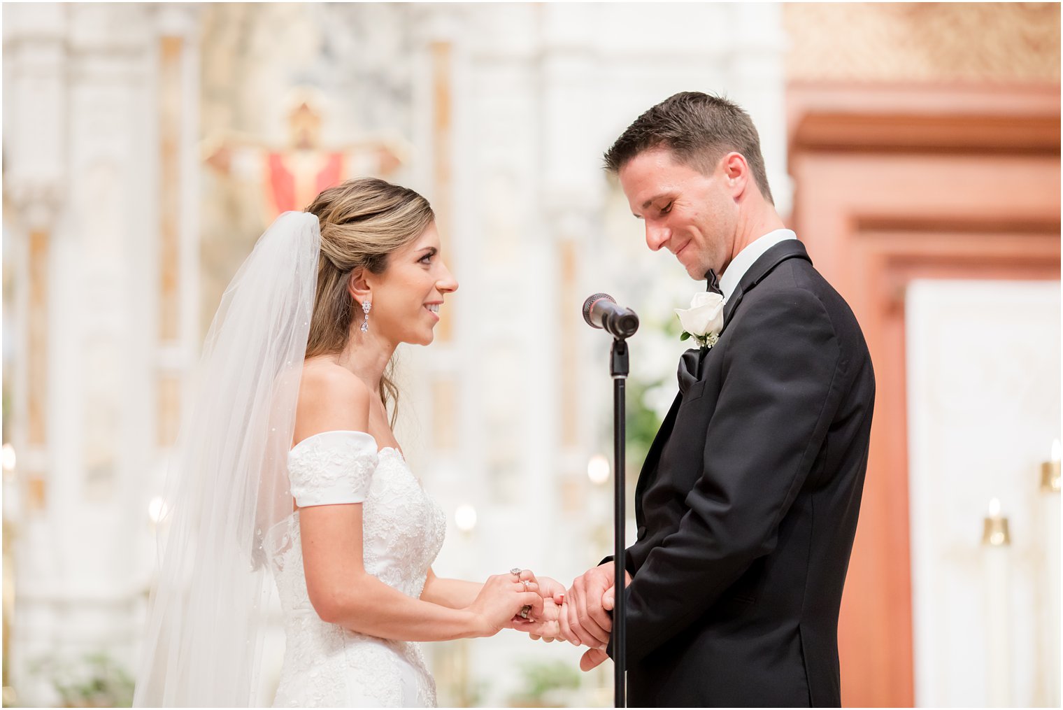 bride gives groom ring during traditional Catholic Church wedding in New Jersey