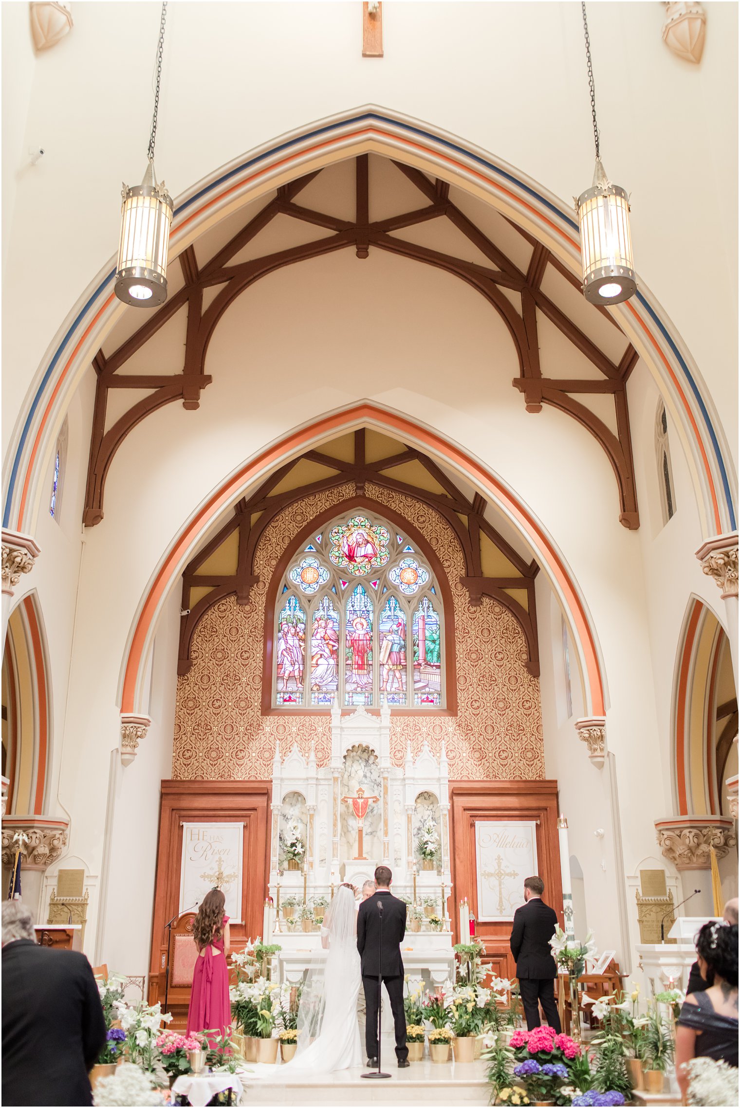 bride and groom stand together at altar during traditional Catholic Church wedding in New Jersey