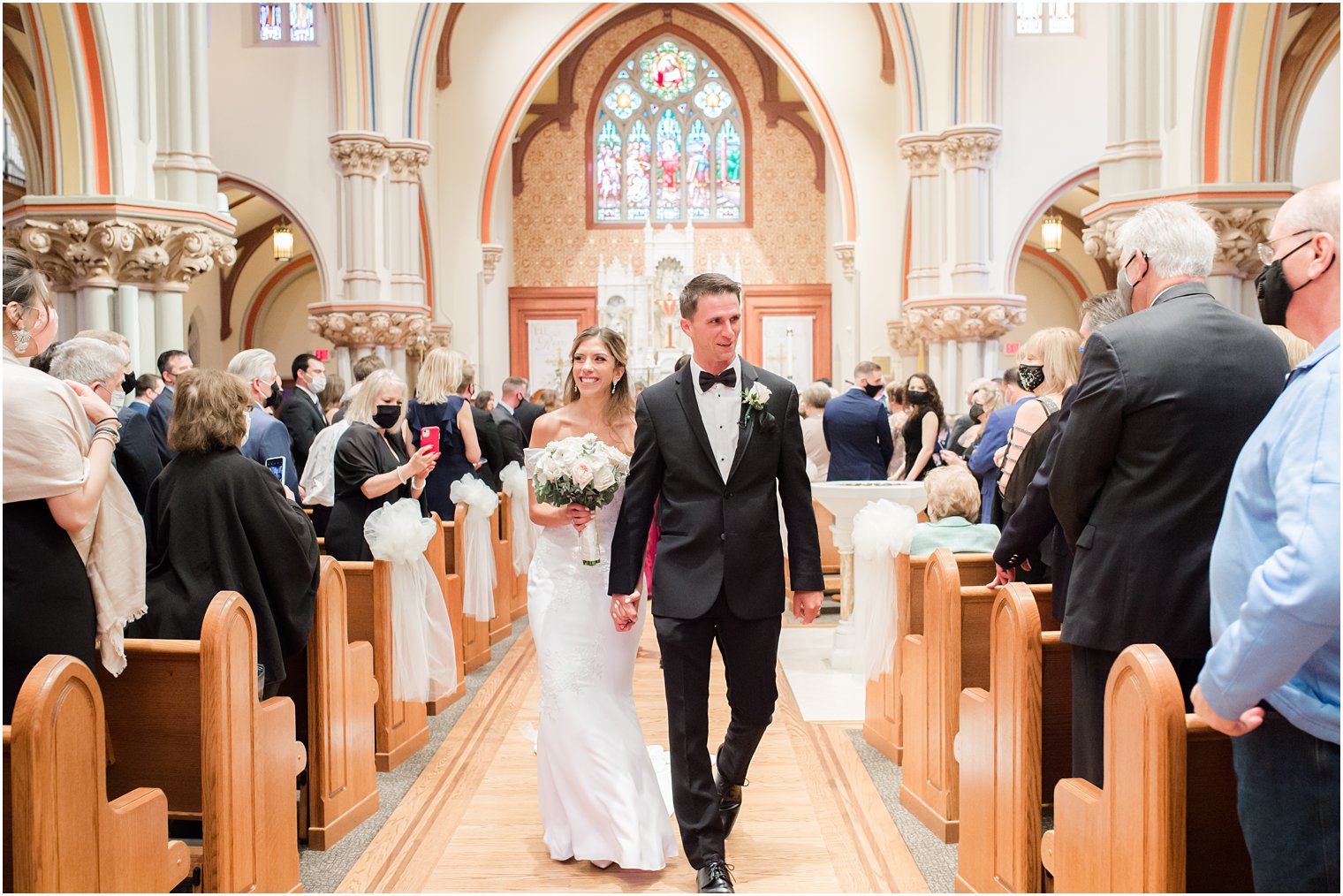 bride and groom leave traditional Catholic Church wedding in New Jersey