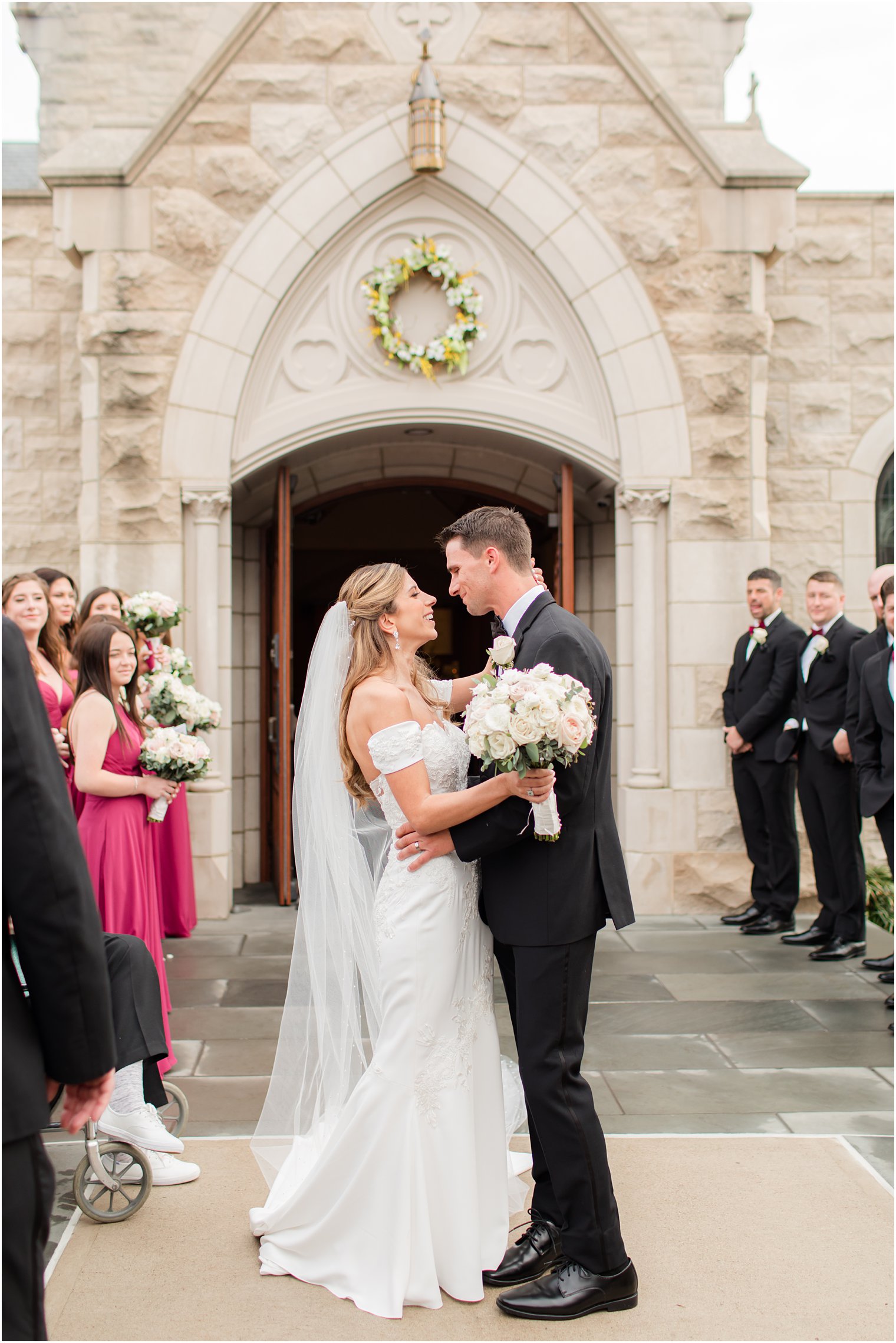 bride and groom smile at each other outside Catholic Church in New Jersey 