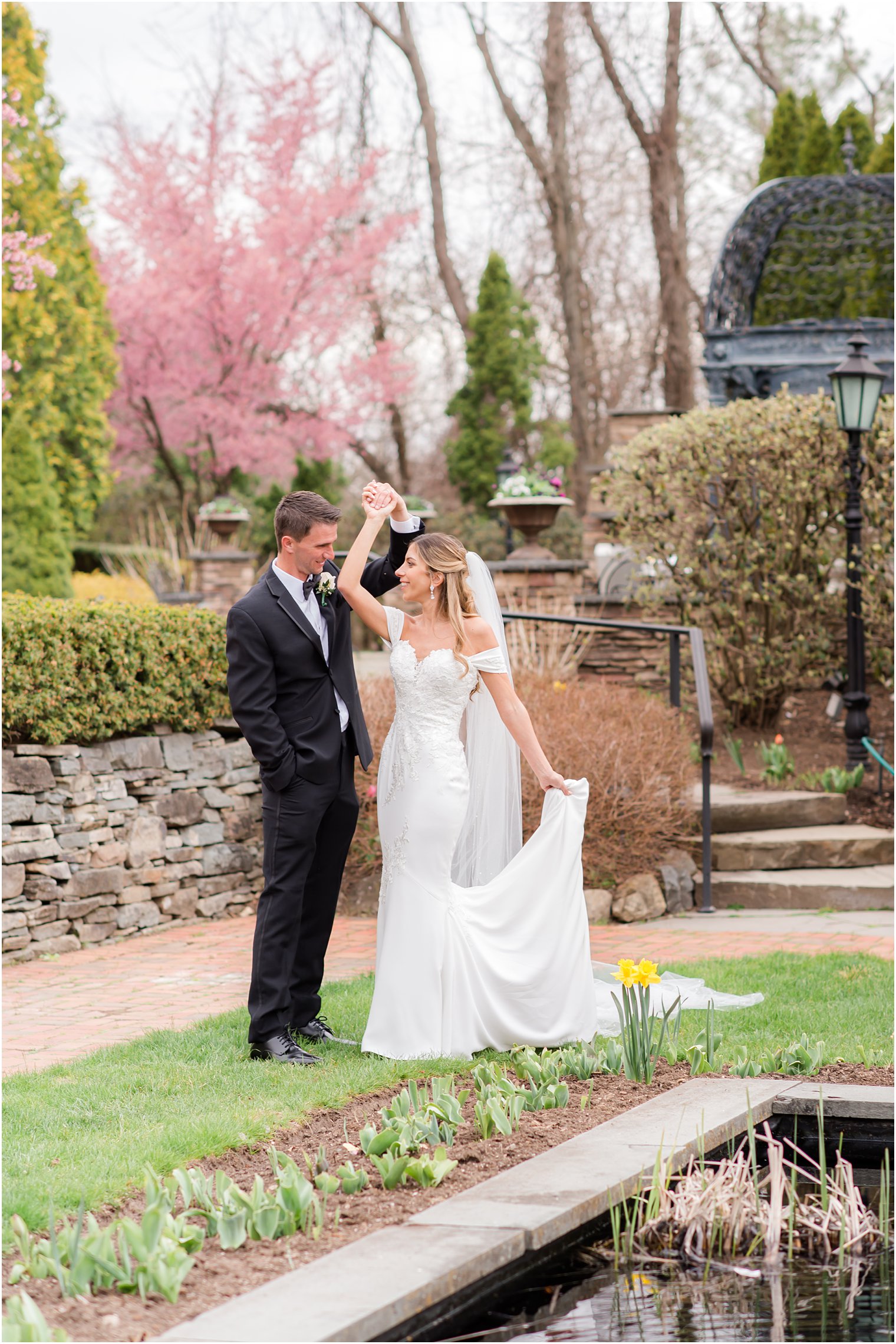 groom twirls bride during springtime wedding photos in Park Savoy Estate gardens 