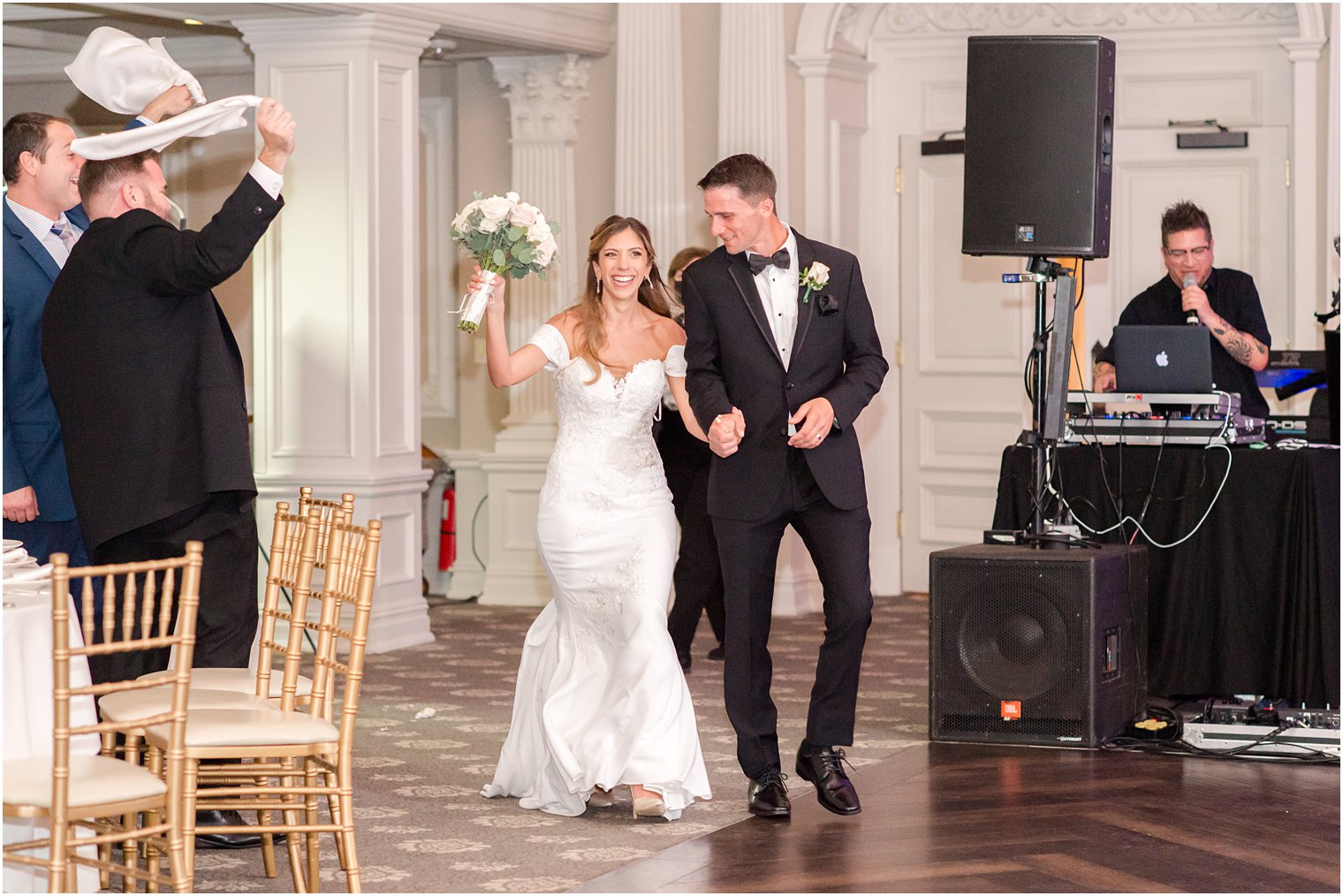 bride and groom hold hands entering New Jersey ballroom wedding reception 