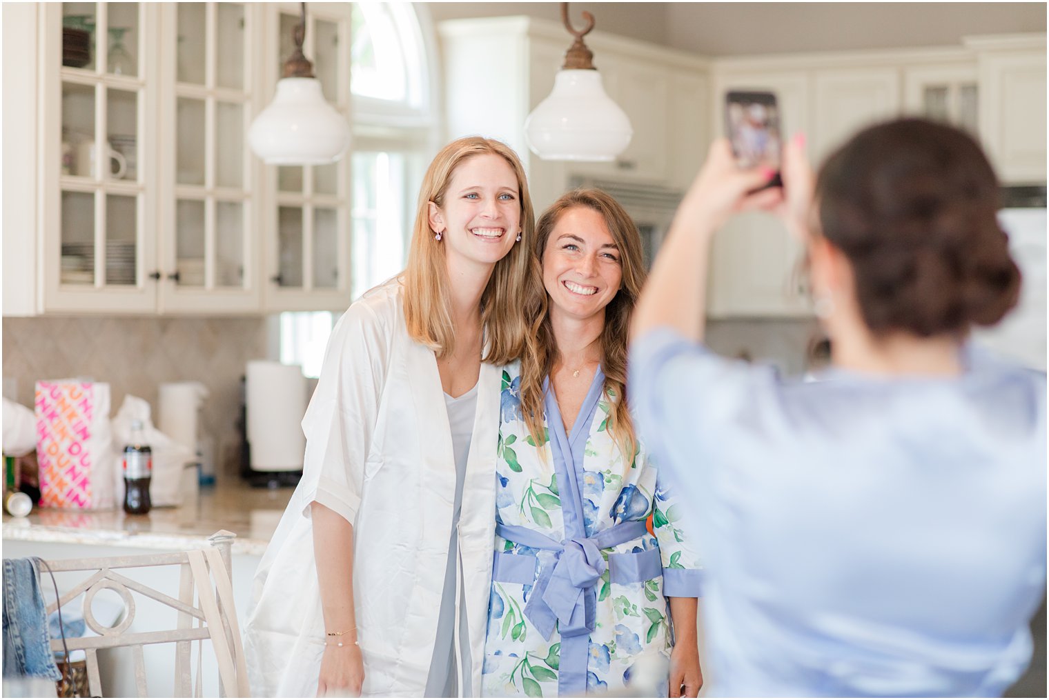 bridesmaid takes photo of bride and bridesmaid before NJ wedding