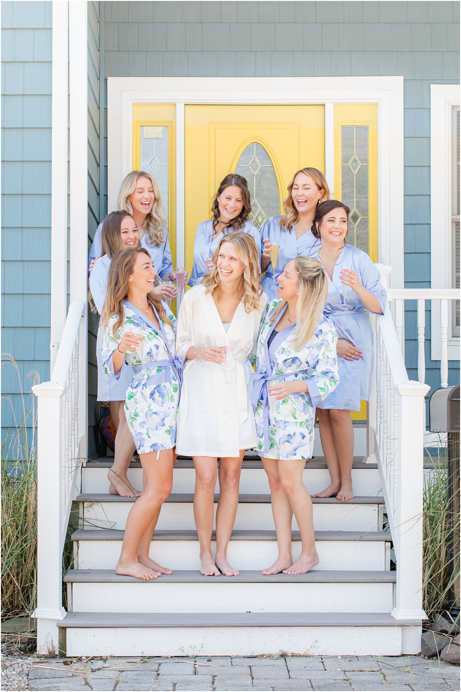 bride laughs with bridesmaids in floral robes before NJ wedding day