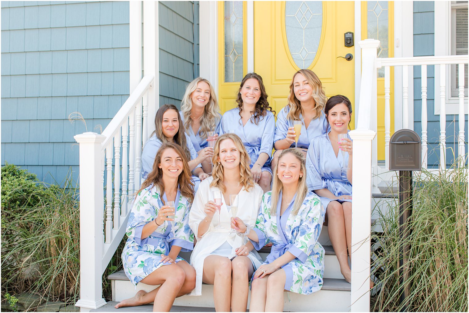 bride and bridesmaids have champagne on front step before NJ wedding 