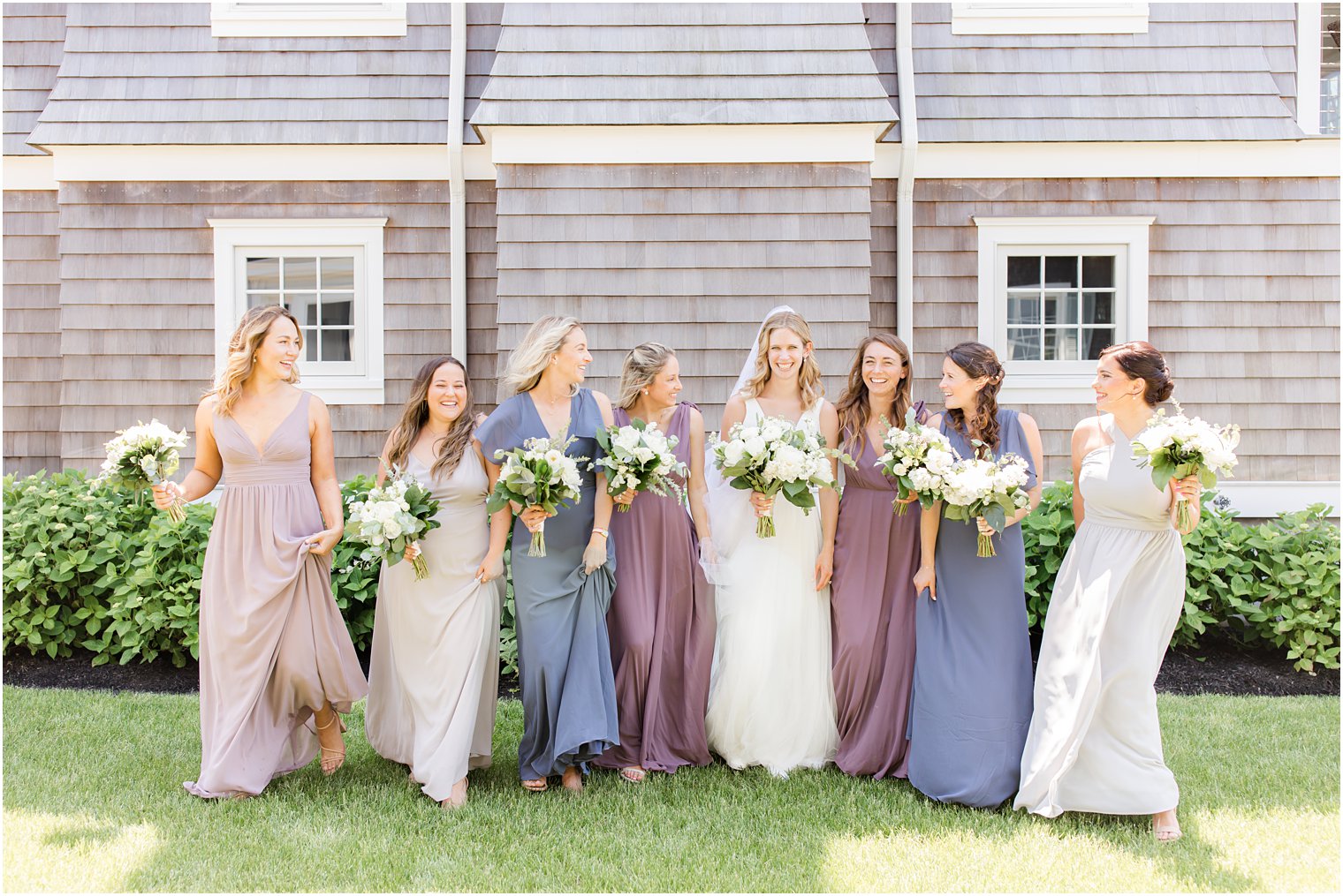 bride walks with bridesmaids in spring color gowns 