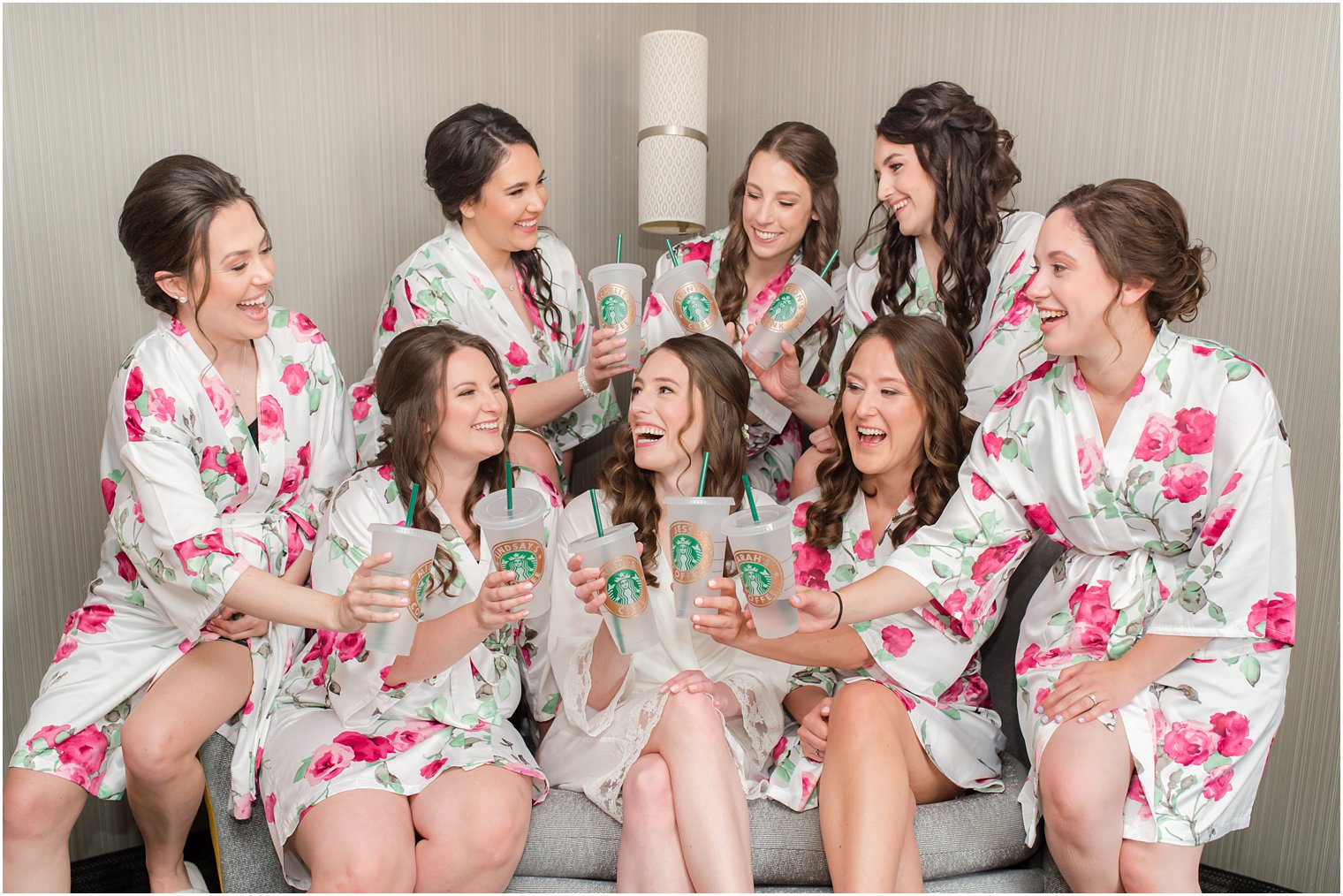 bridesmaids hold custom Starbucks coffee cups while preparing for New Jersey wedding 