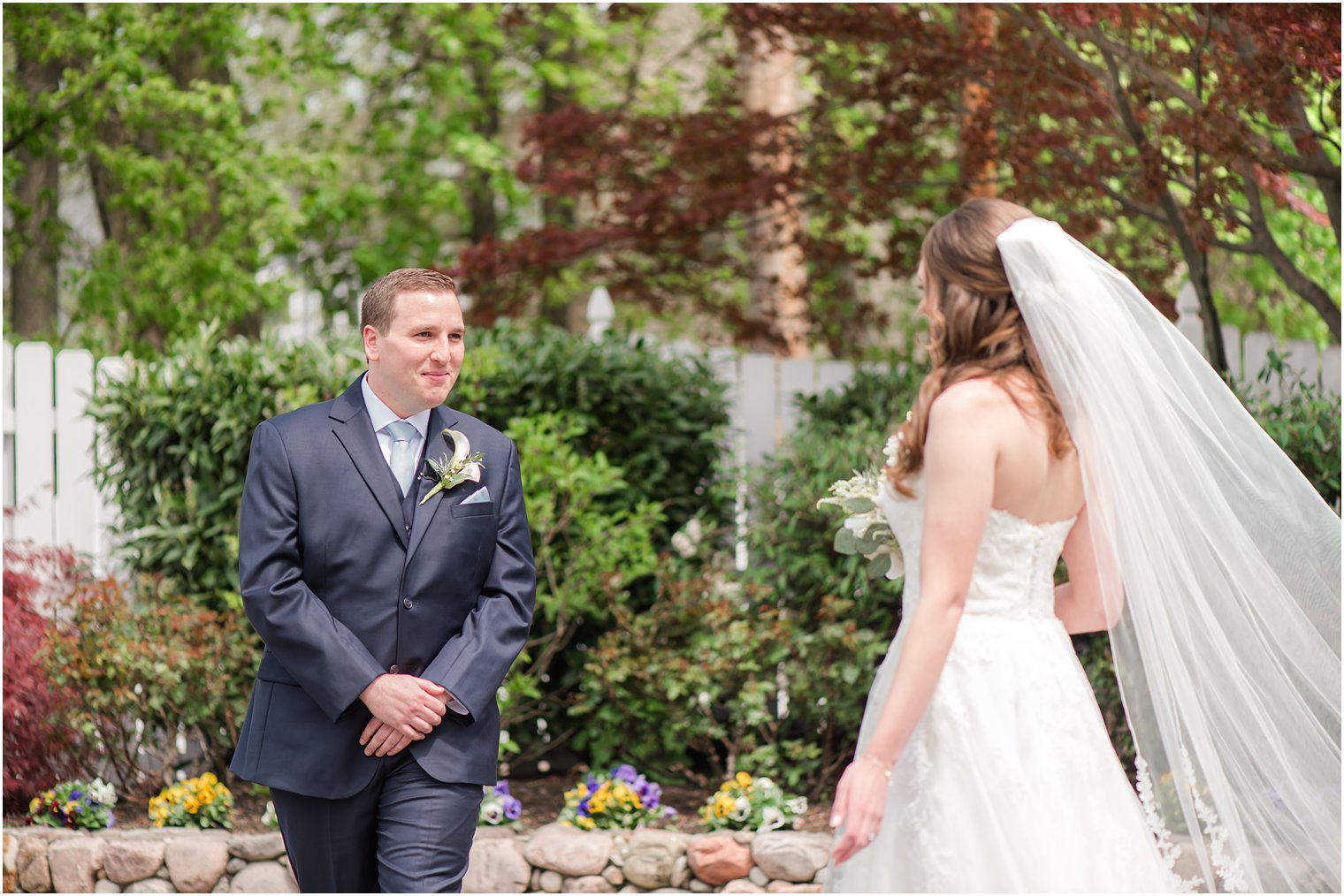 groom looks at bride during first look before spring English Manor wedding ceremony 