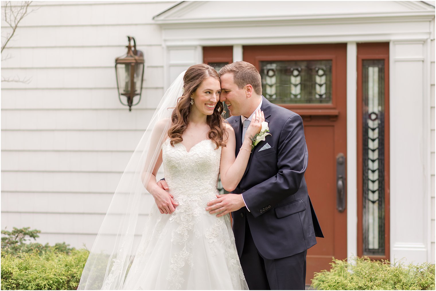 bride holds groom's cheek to her cheek during NJ wedding photos 