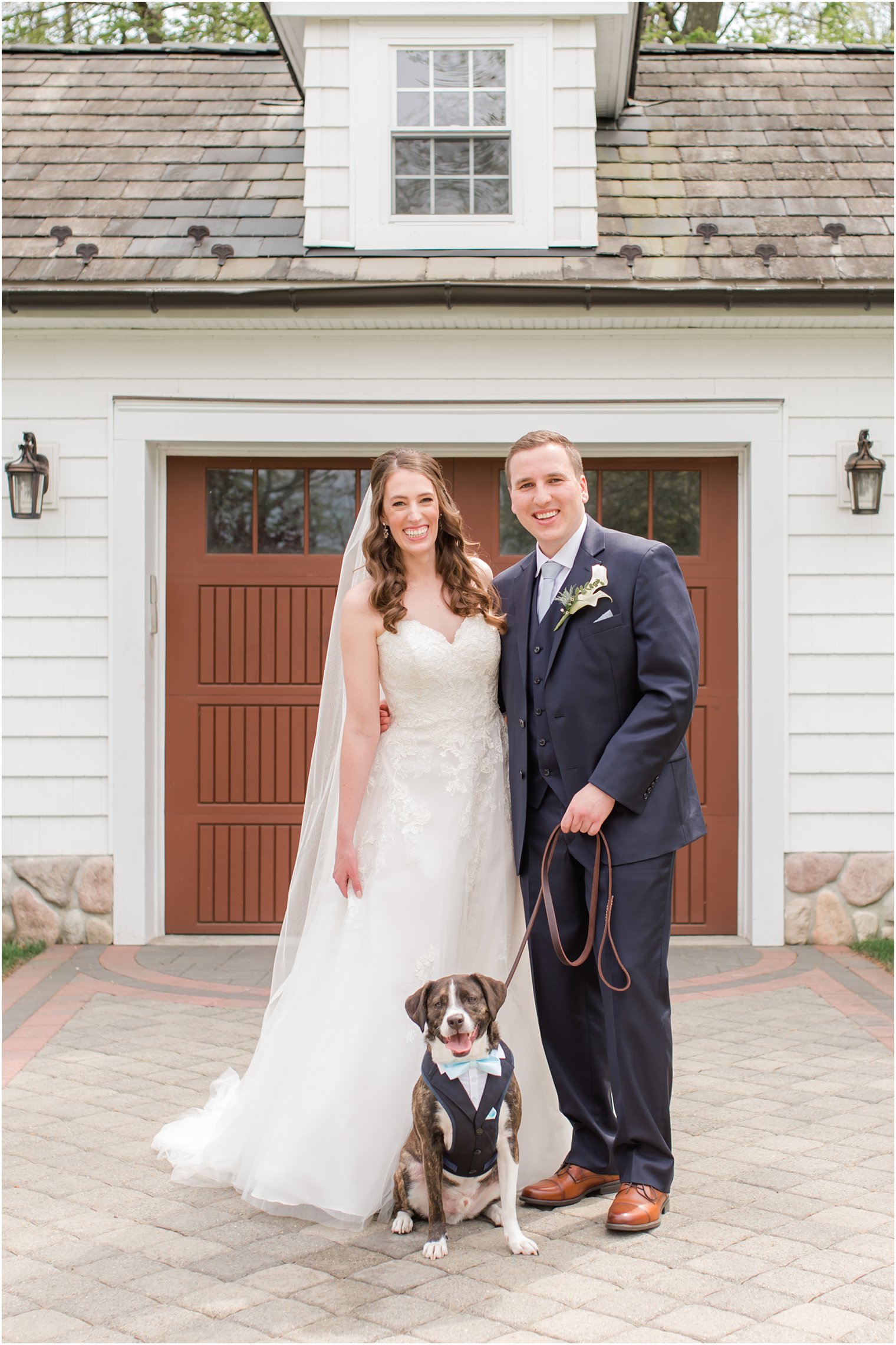 newlyweds pose with dog sitting outside The English Manor 