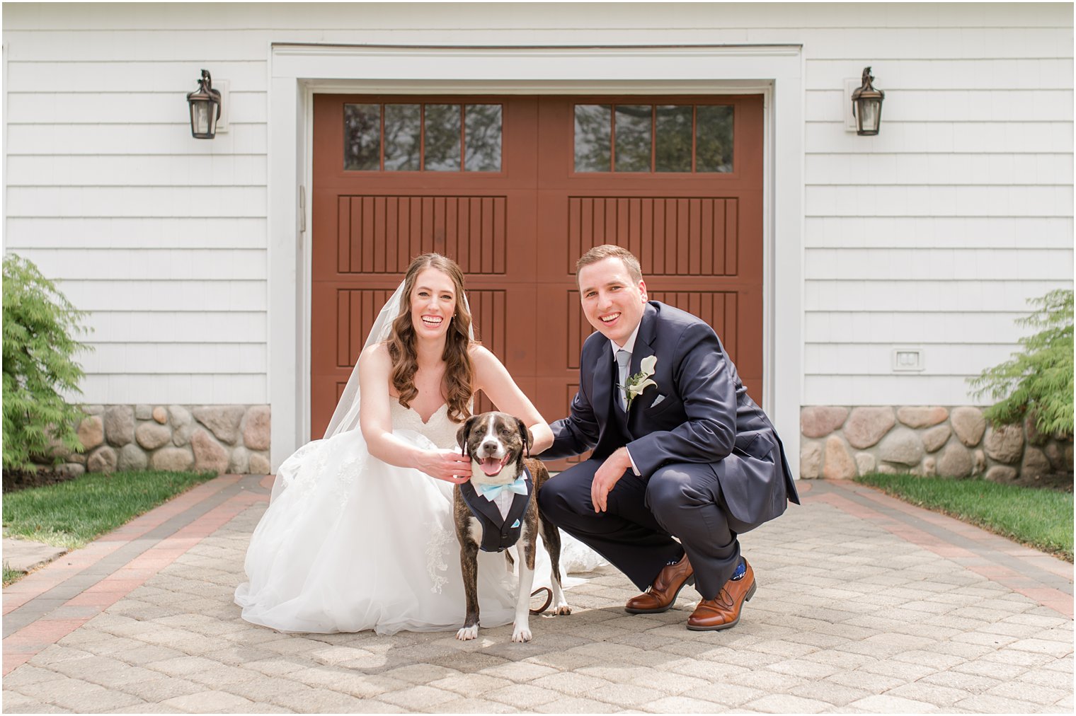 bride and groom pose with dog wearing light blue bowtie before spring NJ wedding