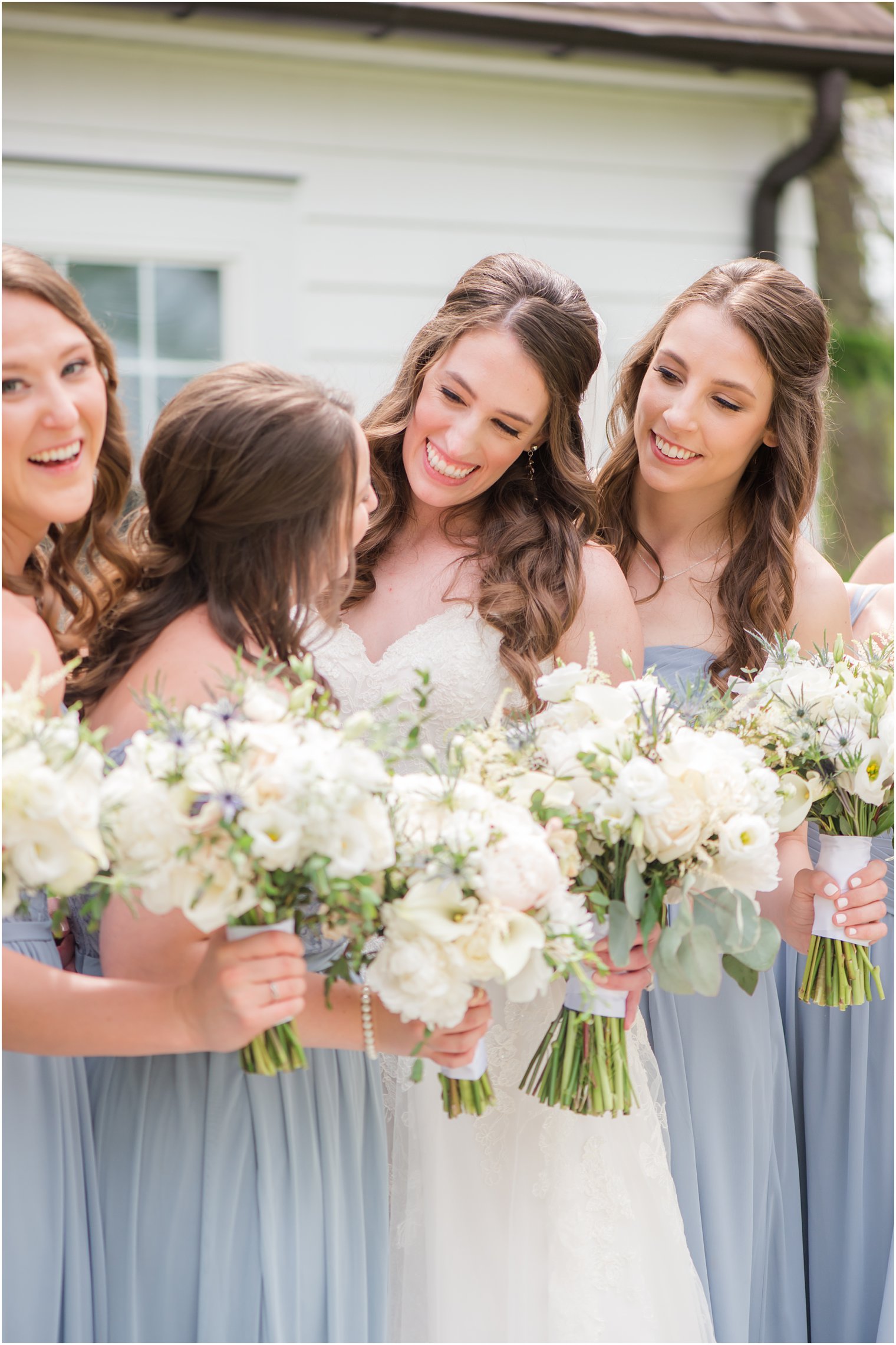 bride laughs with bridesmaids before NJ wedding ceremony 