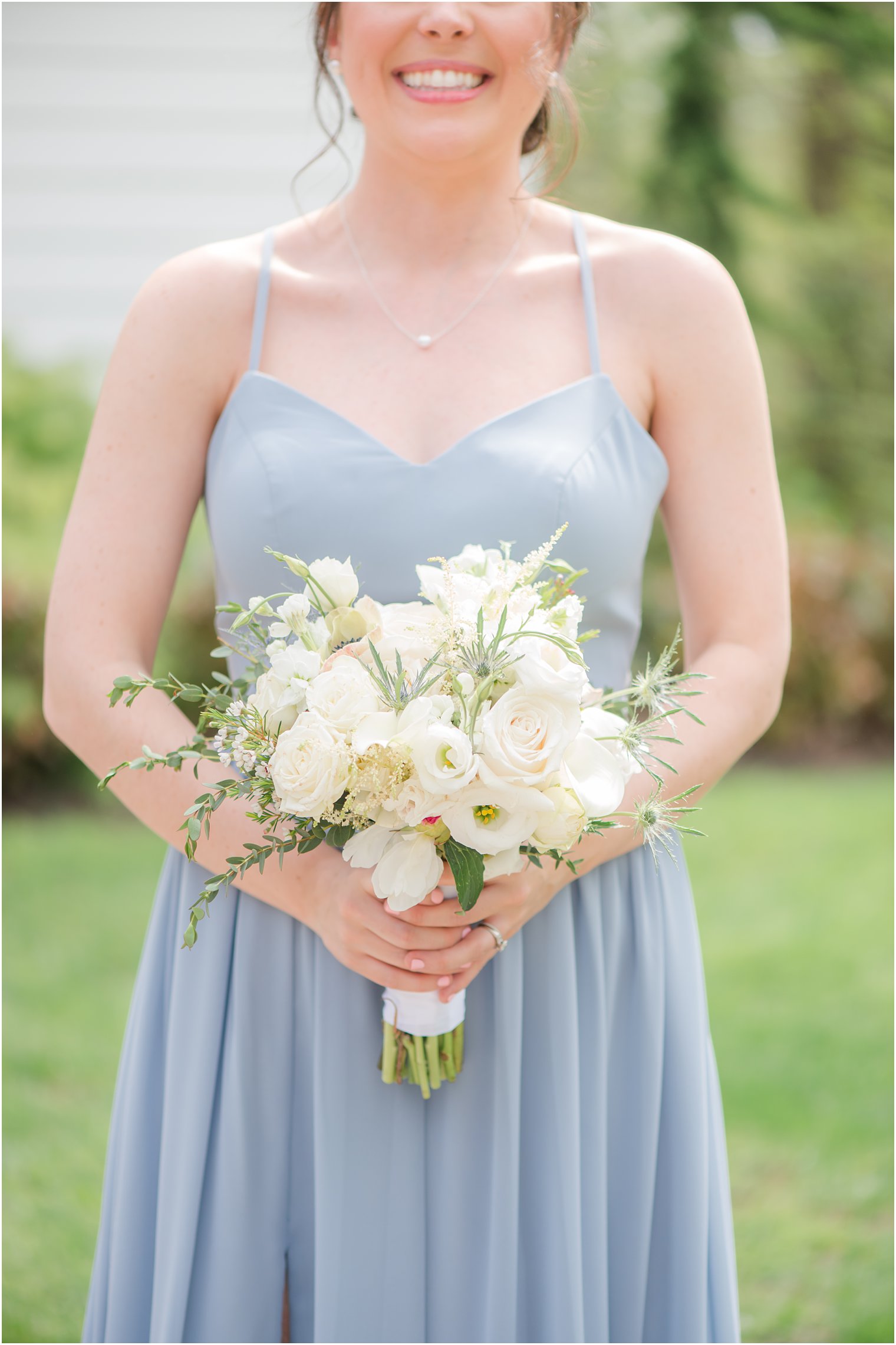 bride holds bouquet of white flowers for spring English Manor wedding