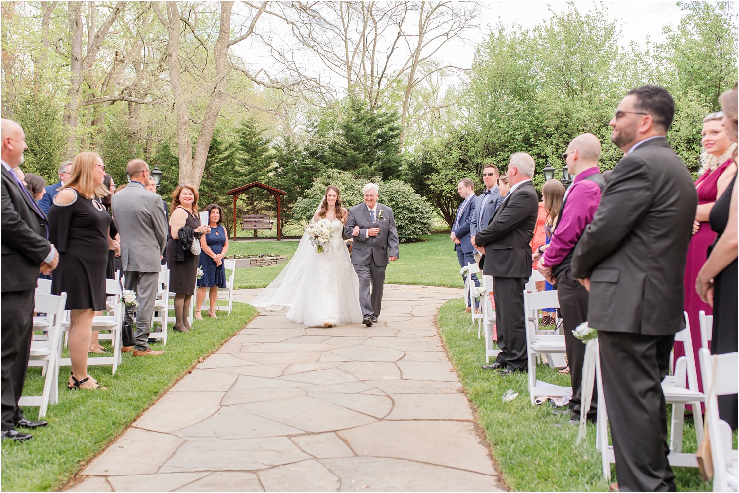 bride walks down aisle with dad at spring English Manor wedding