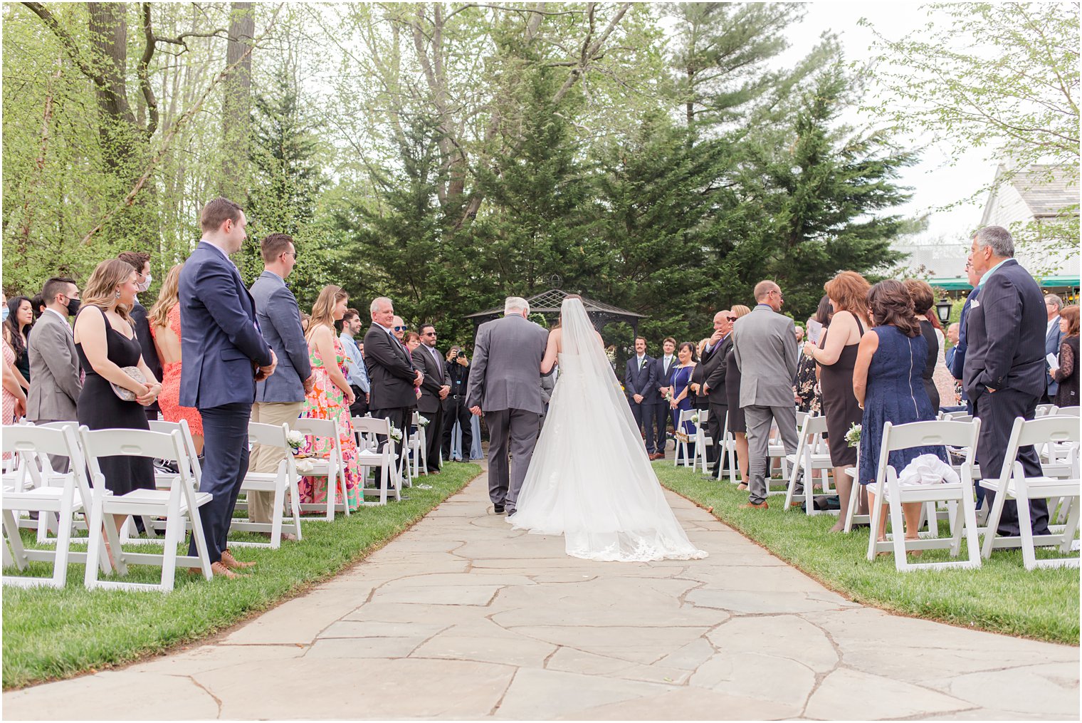 bride walks down aisle during garden wedding ceremony at The English Manor 
