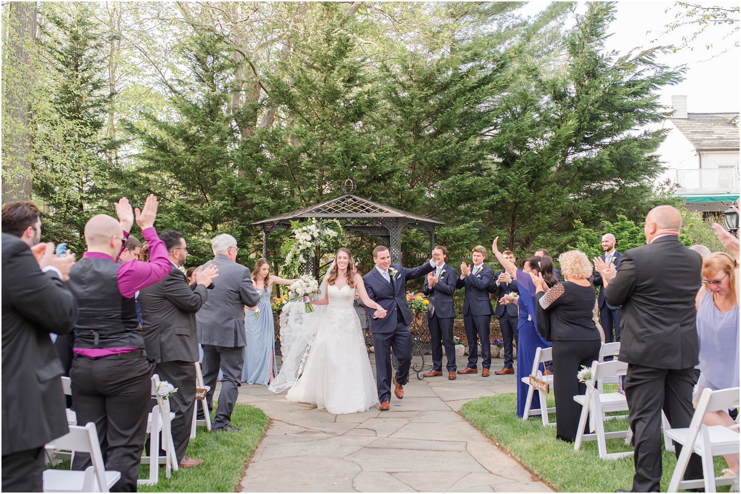 bride and groom walk down aisle during spring English Manor wedding ceremony 