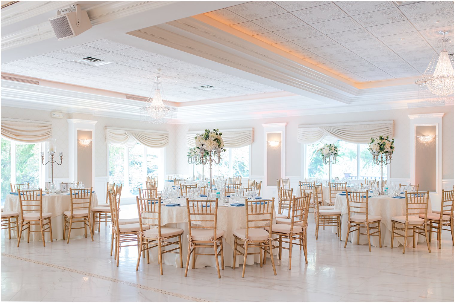 spring English Manor wedding reception with gold chivari chairs and tall floral centerpieces 