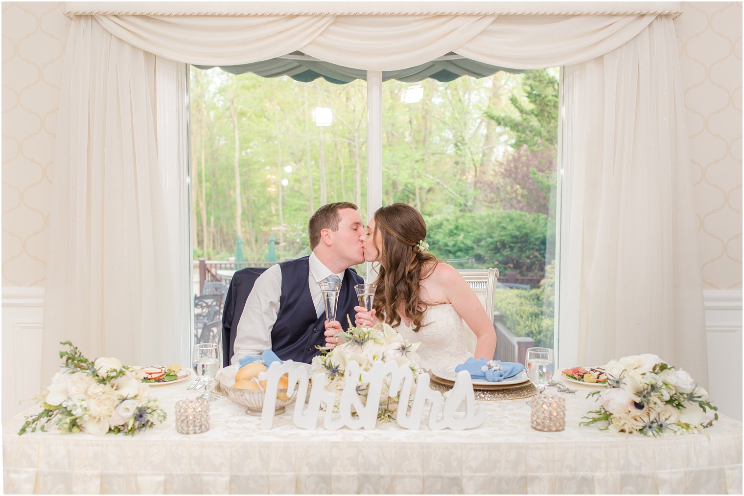 couple kisses at sweetheart table during NJ wedding reception