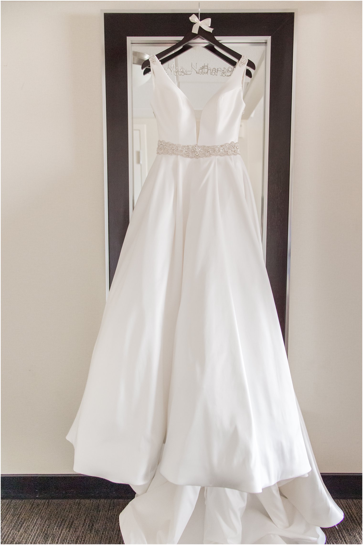 wedding gown hangs on mirror before NJ wedding