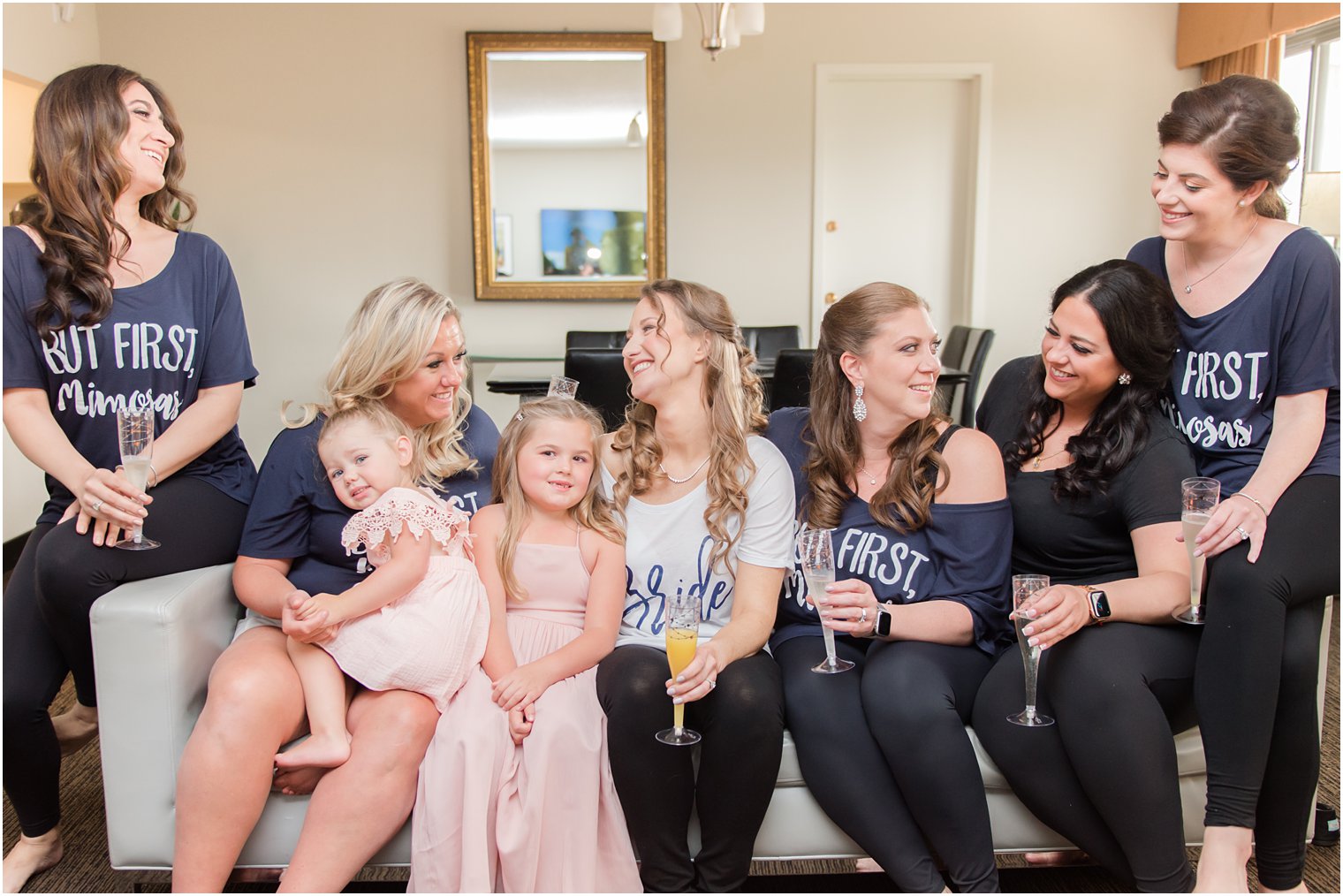 bride and bridesmaids smile at each other during wedding morning prep