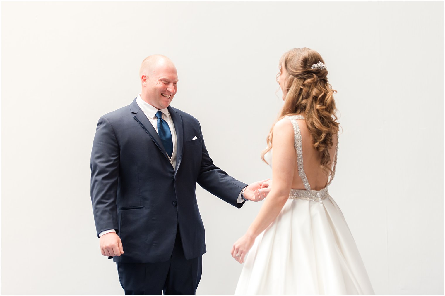 groom smiles at bride during first look before NJ wedding day