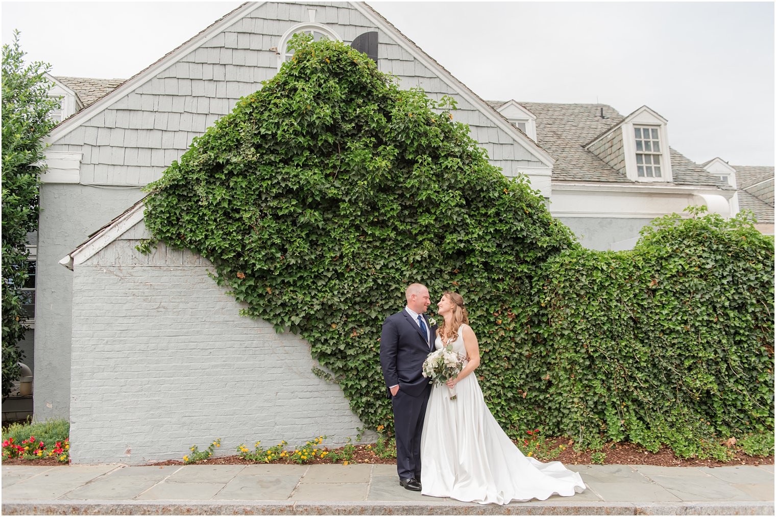 quiet moment between bride and groom along ivy covered wall at Forsgate Country Club
