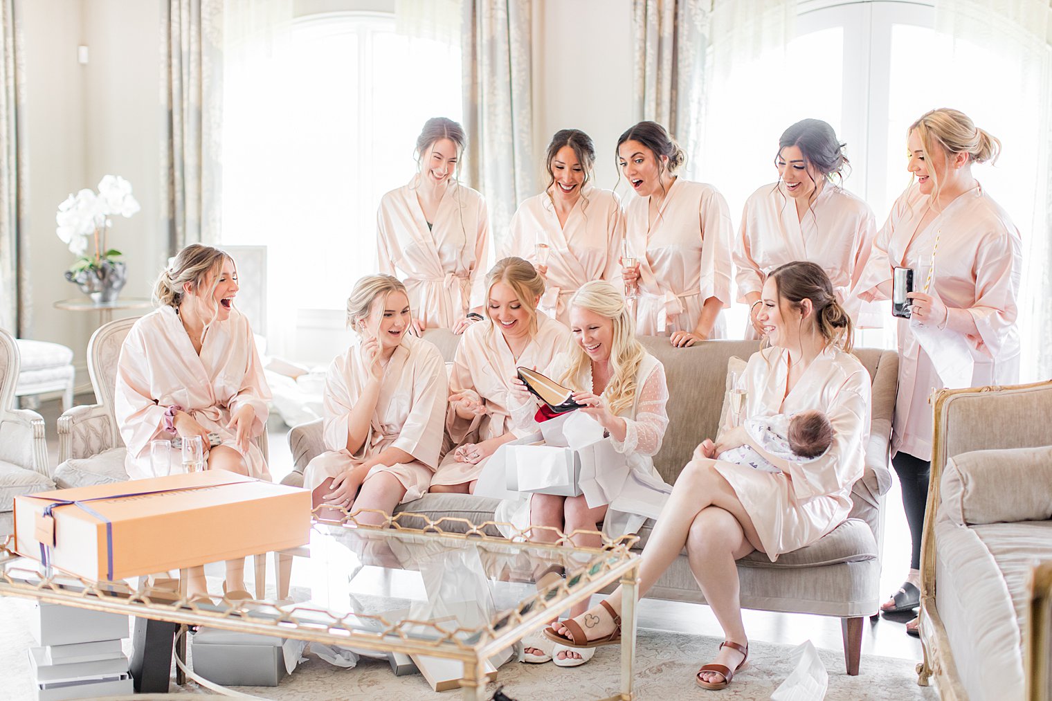 bride and bridesmaids look at shoes during wedding day prep