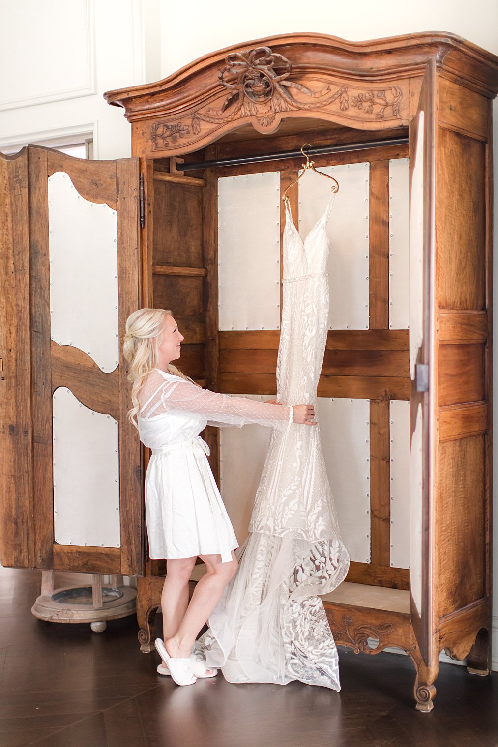 bride looks at wedding dress hanging in wardrobe at Park Chateau Estate