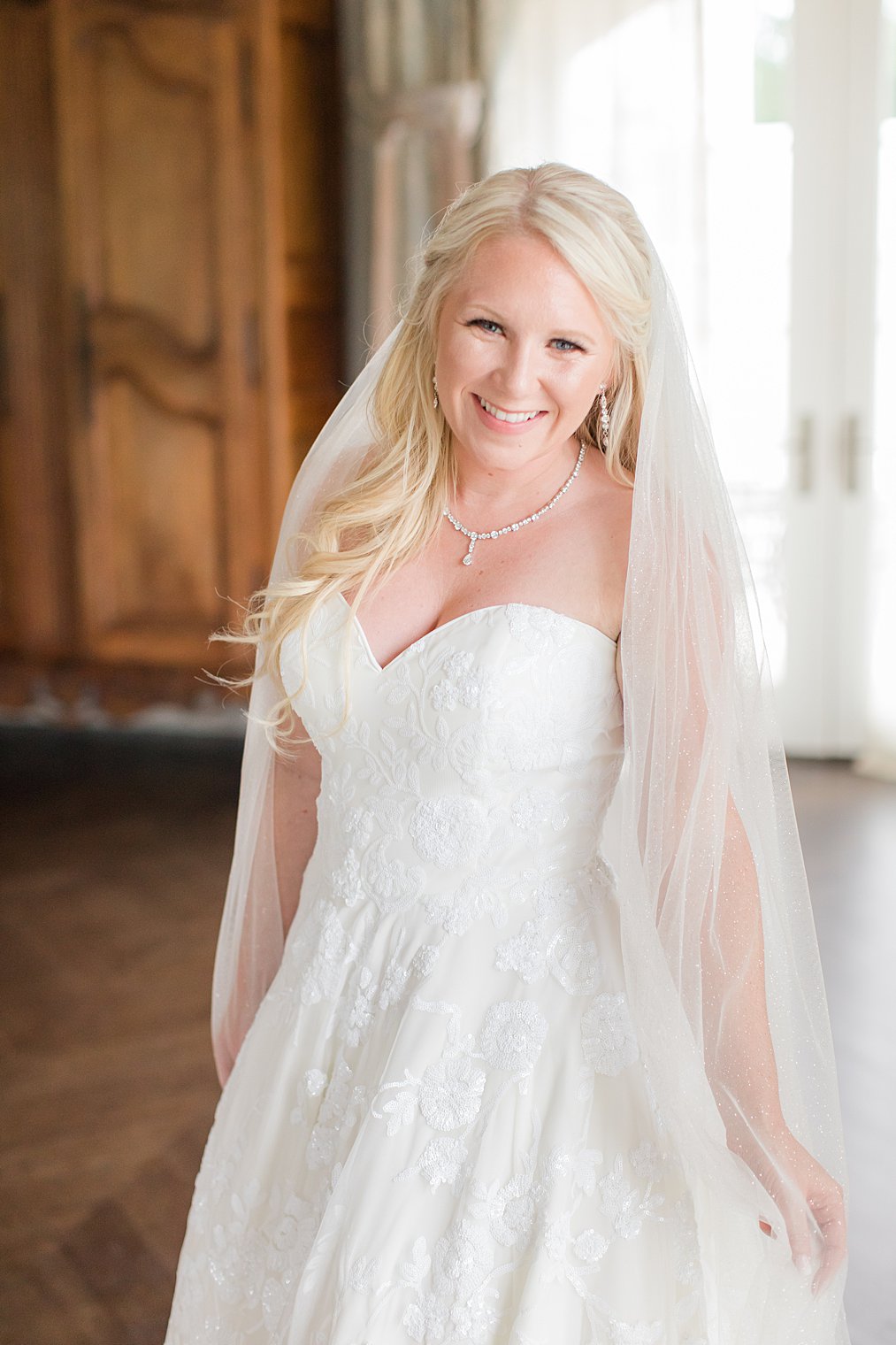 bride smiles during portraits in Park Chateau Estate bridal suite 