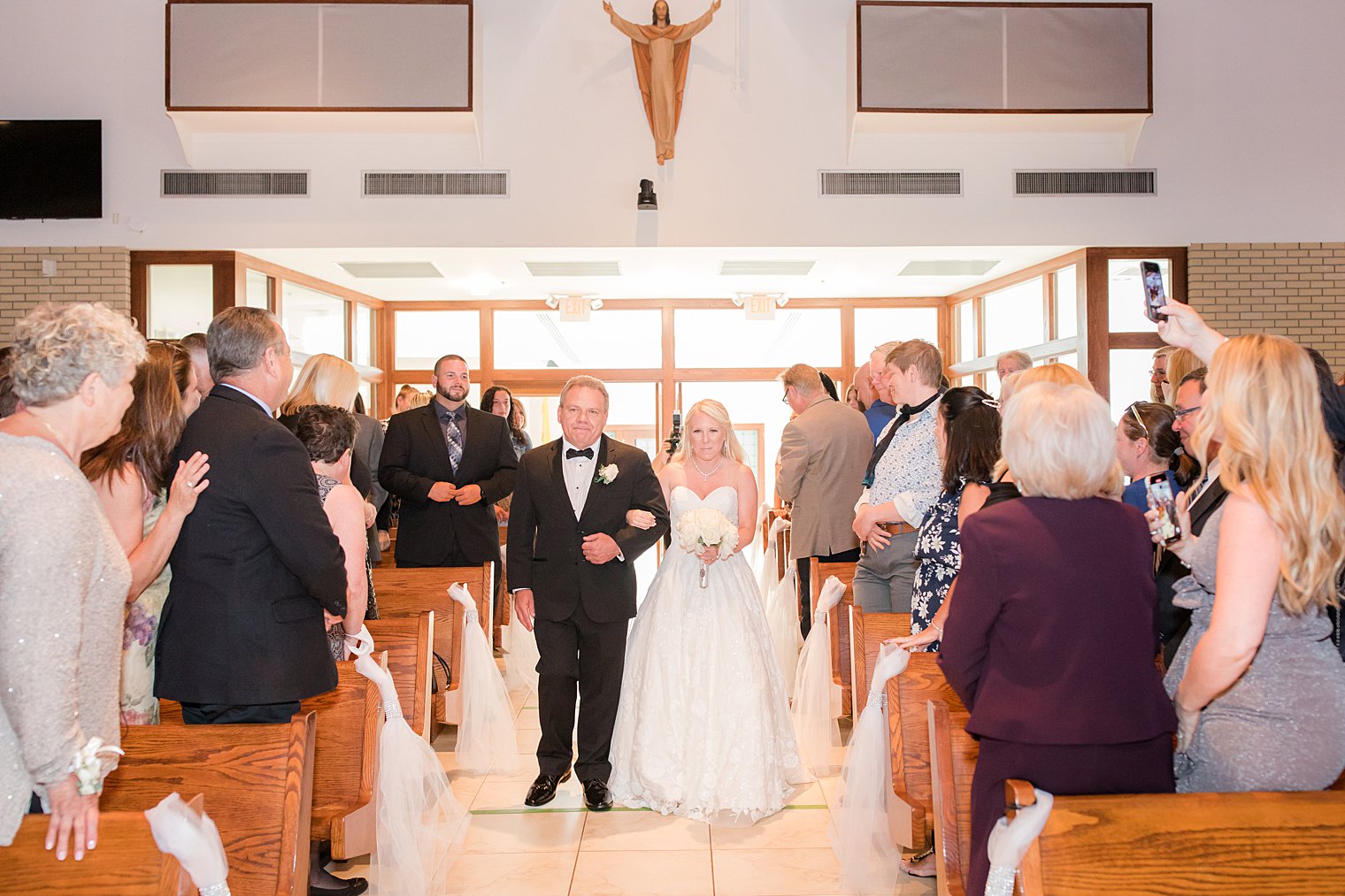 bride walks down aisle with father during traditional church wedding in New Jersey
