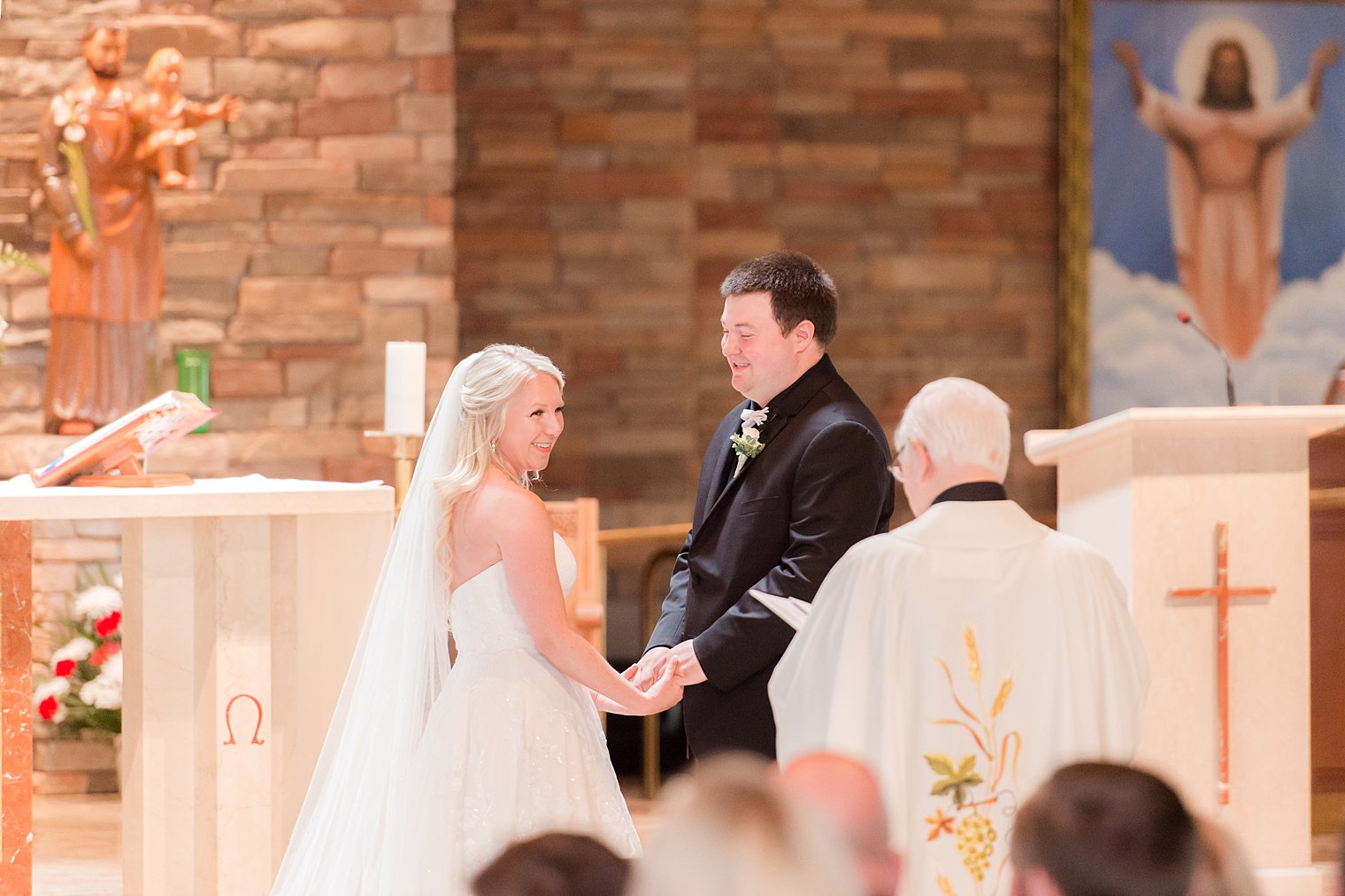 married couple holds hands together during ceremony in church