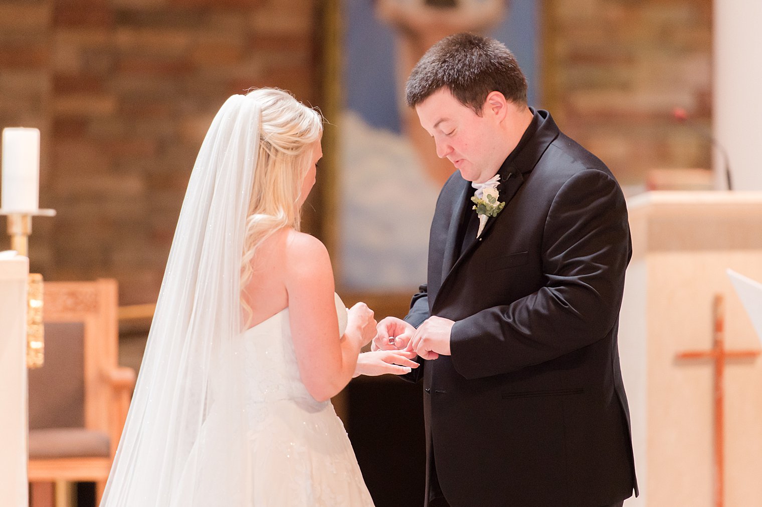 couple exchanges rings during traditional church wedding in New Jersey