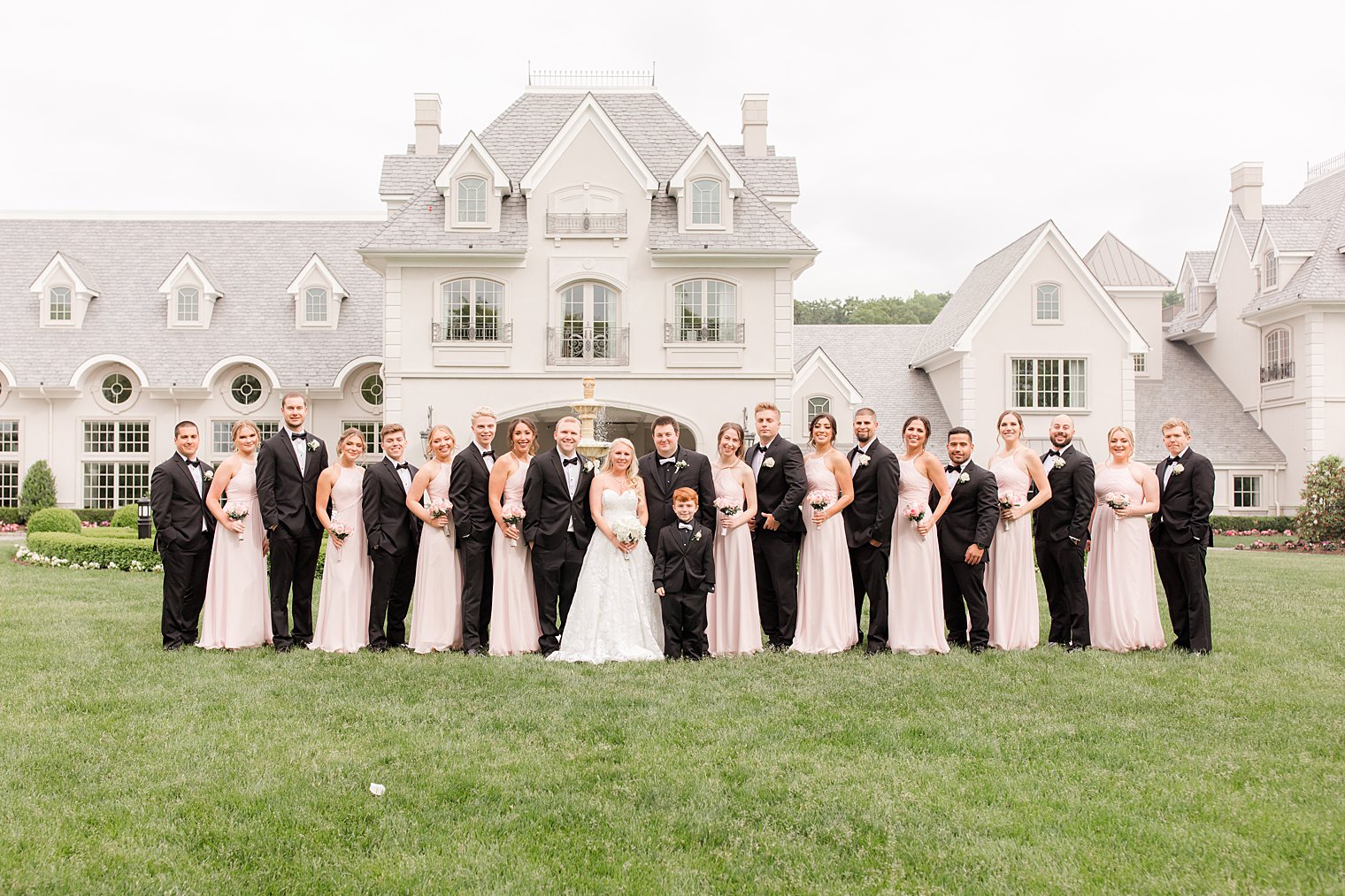 newlyweds pose with bridal party in pale pink and black