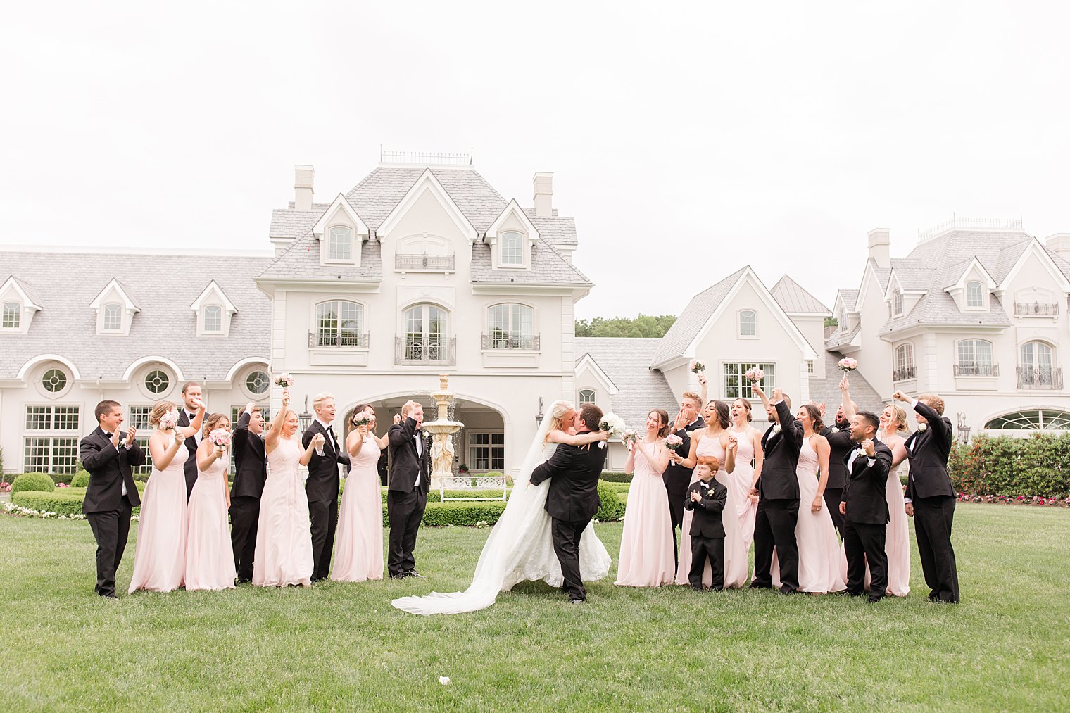 groom lifts bride up during portraits with bridal party