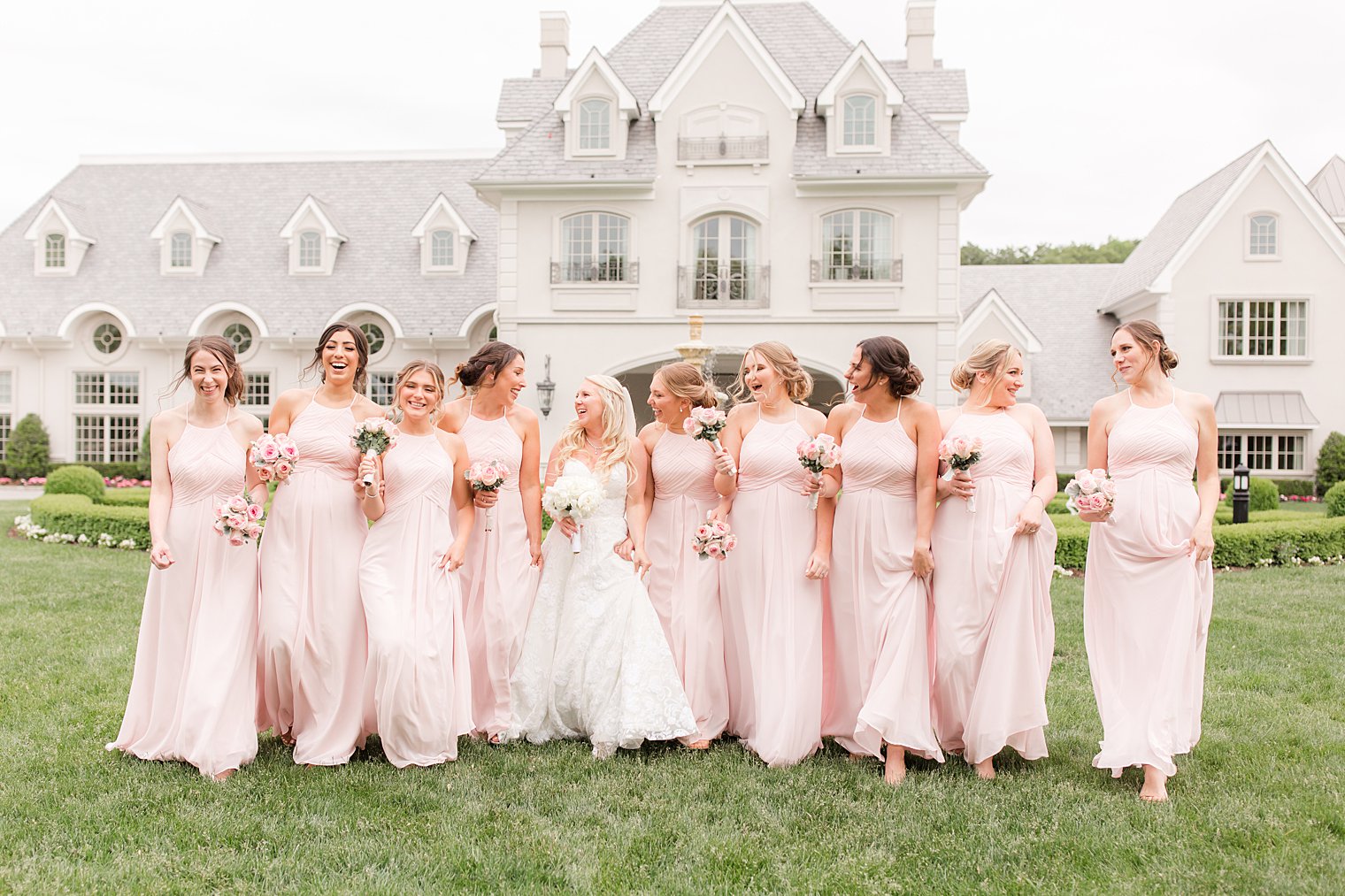 bride walks with bridesmaids in pastel pink gowns