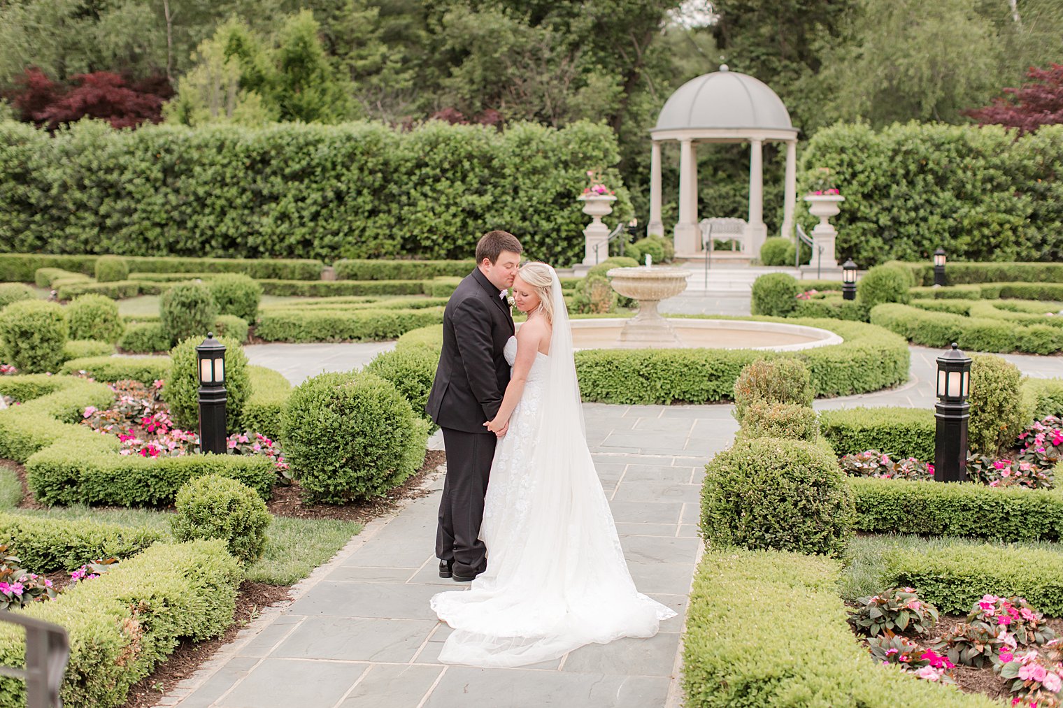 bride and groom pose in gardens at Park Chateau Estate