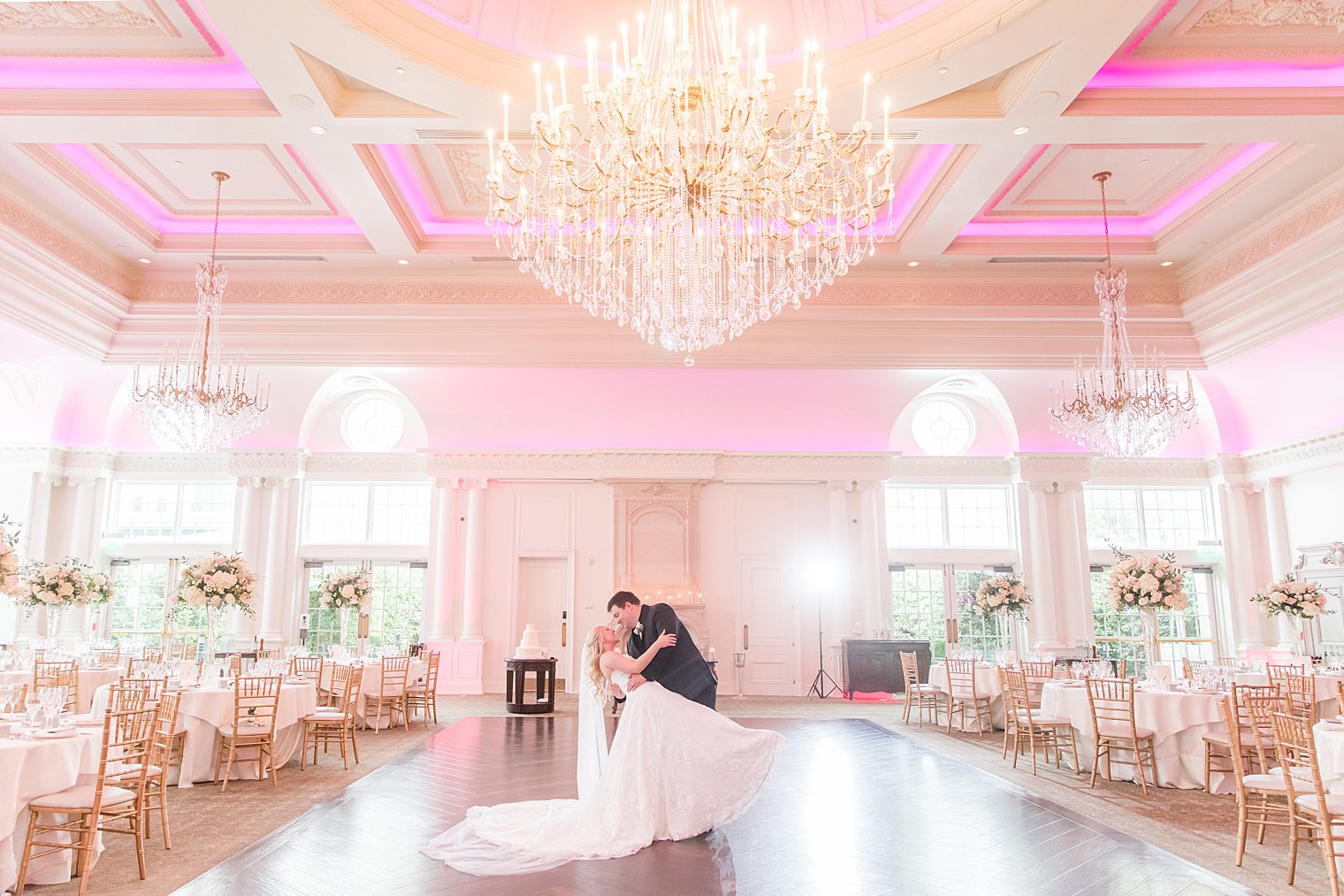 newlyweds kiss on ballroom floor at Park Chateau Estate