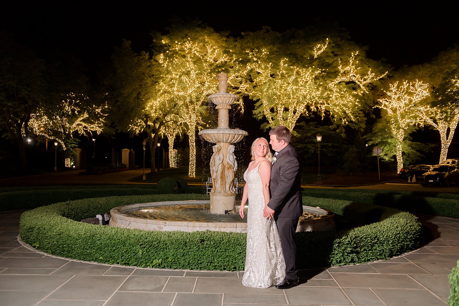 nighttime portrait by fountain in gardens at Park Chateau Estate