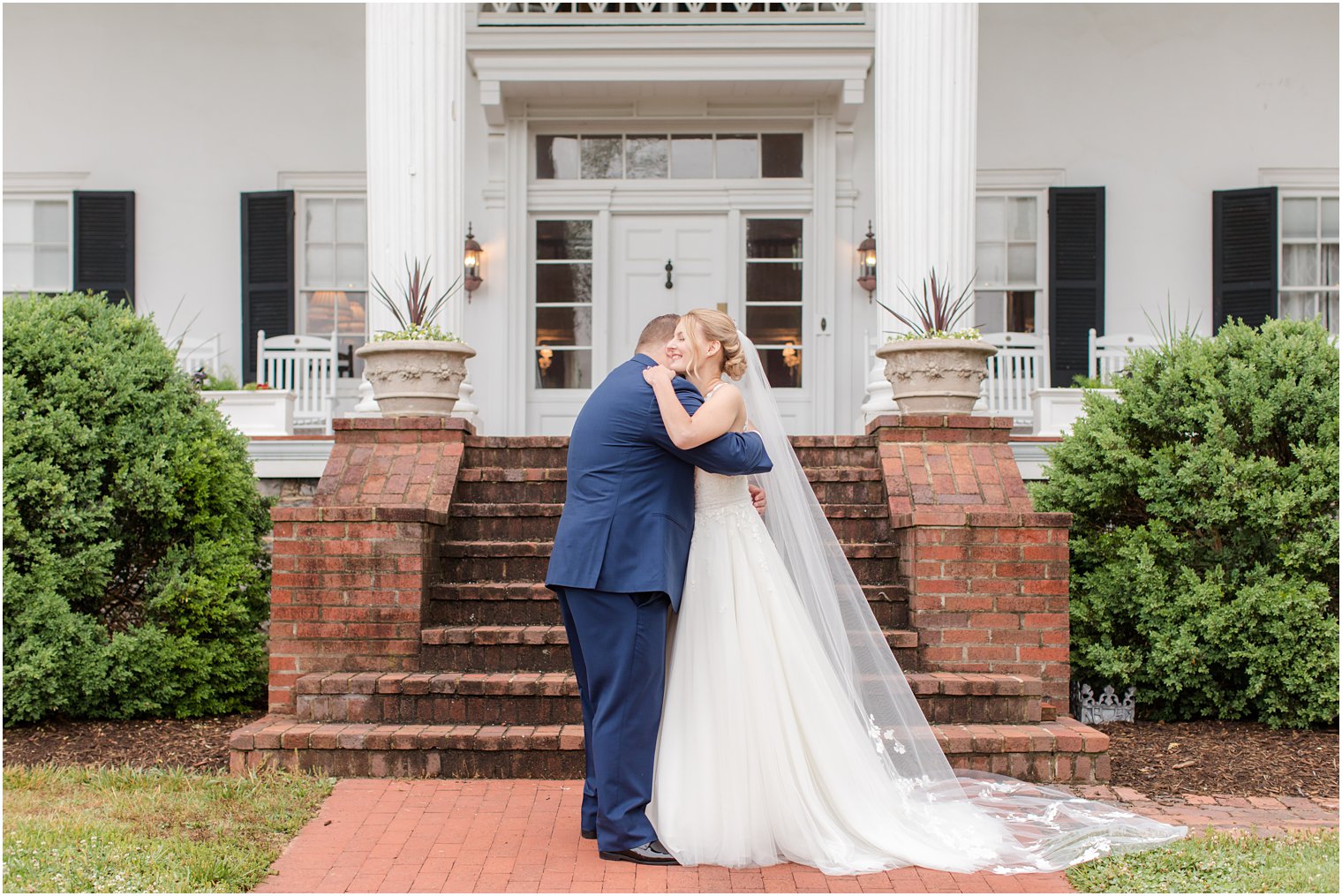 bride and groom hug on front steps at Rosemont Manor
