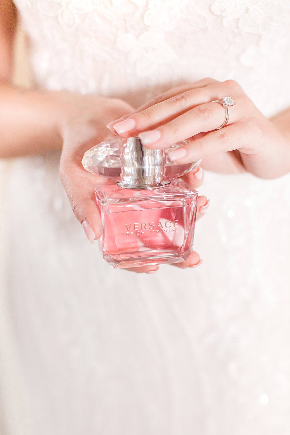 bride holds Versace perfume while preparing for New York wedding day 