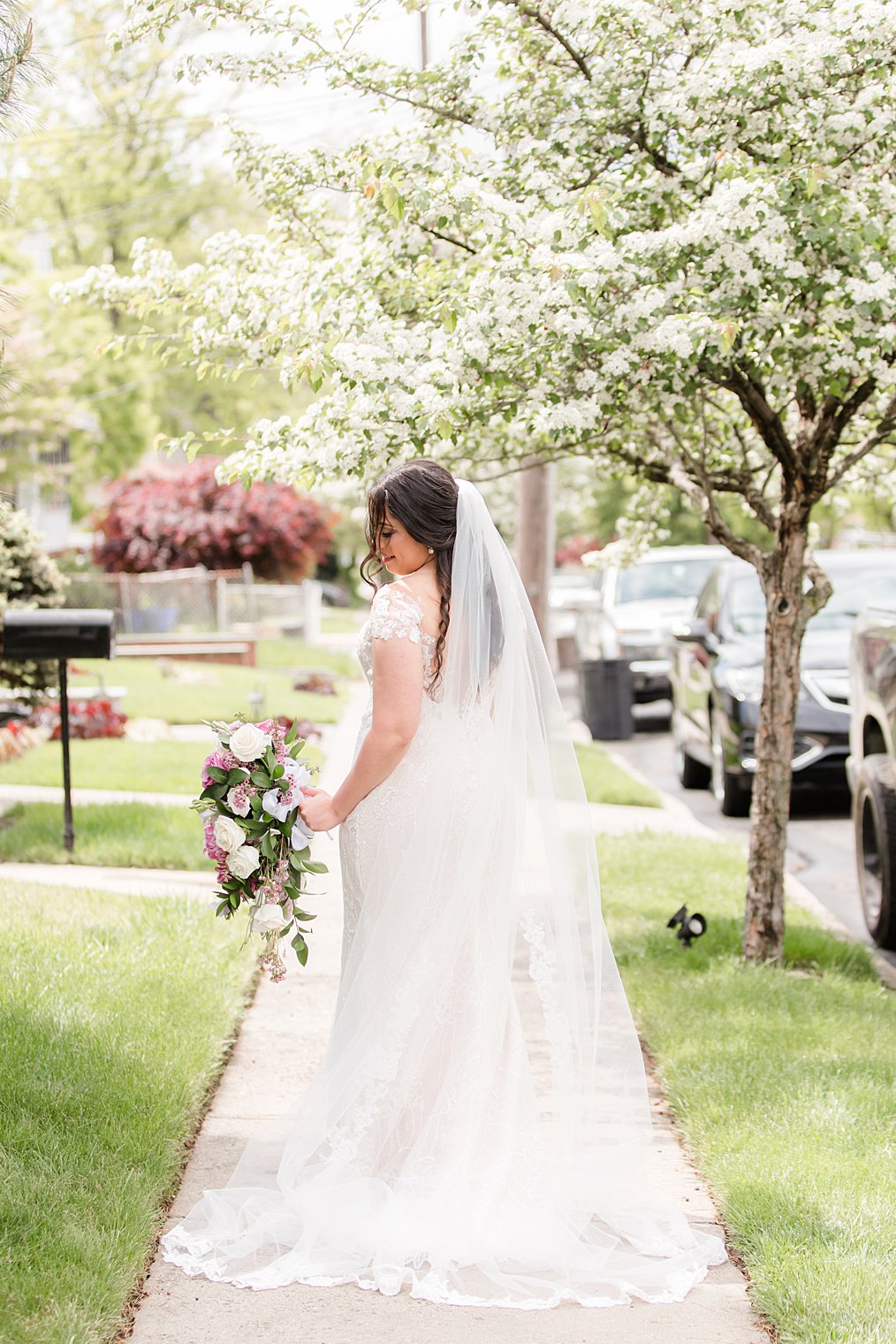 bride looks over shoulder during spring bridal portraits in Staten Island neighborhood 